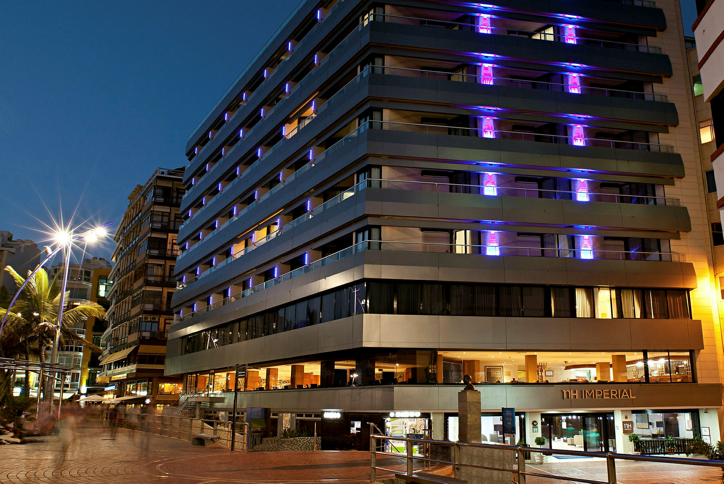 Et moderne hotell på en bygate med nattbelysning. (AI-generert tekst)
