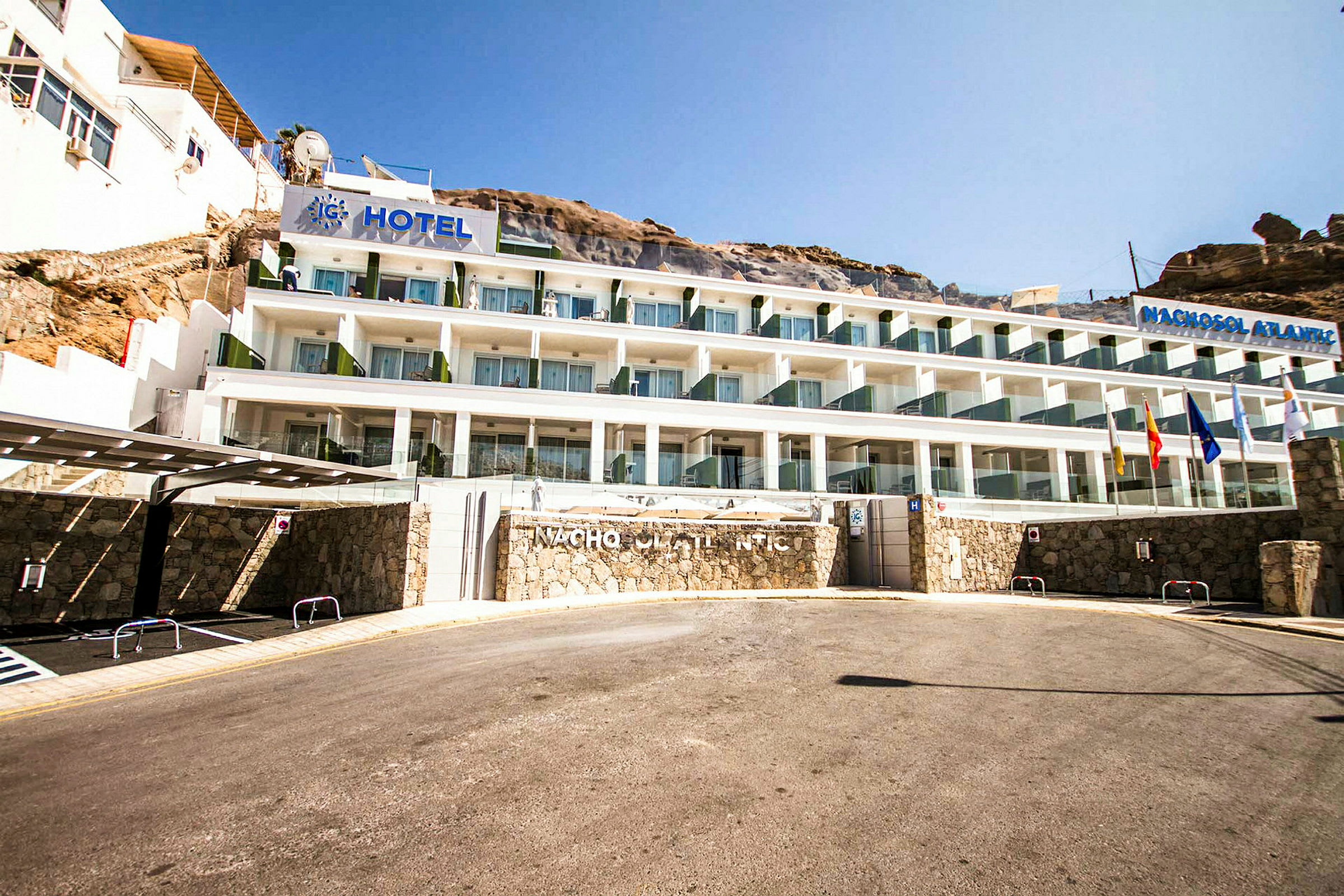 Hotellbygning med flere etasjer, plassert ved en skråning. (AI-generert tekst)