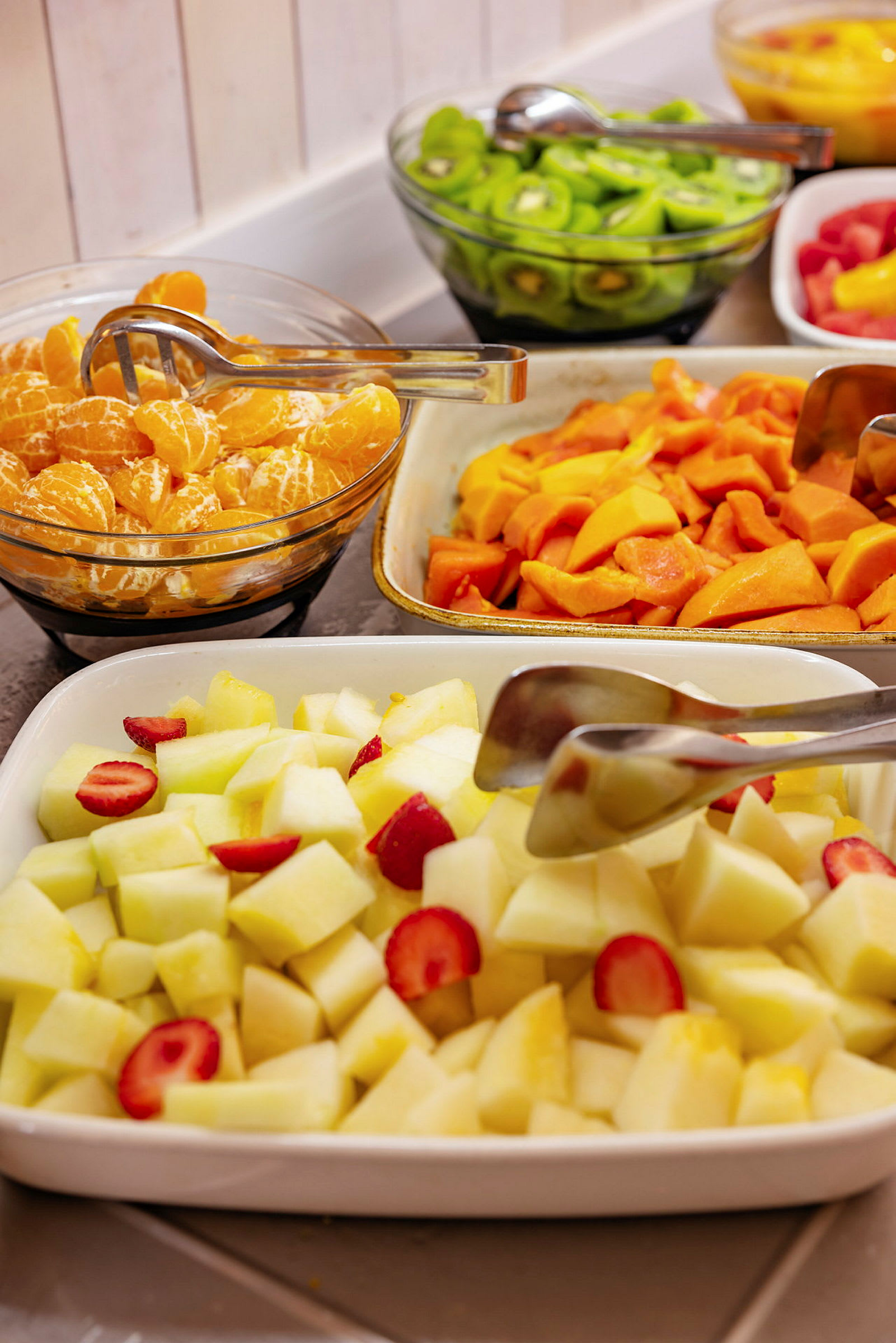 Fruktbuffet med melon, jordbær, kiwi og sitrusfrukter. (AI-generert tekst)