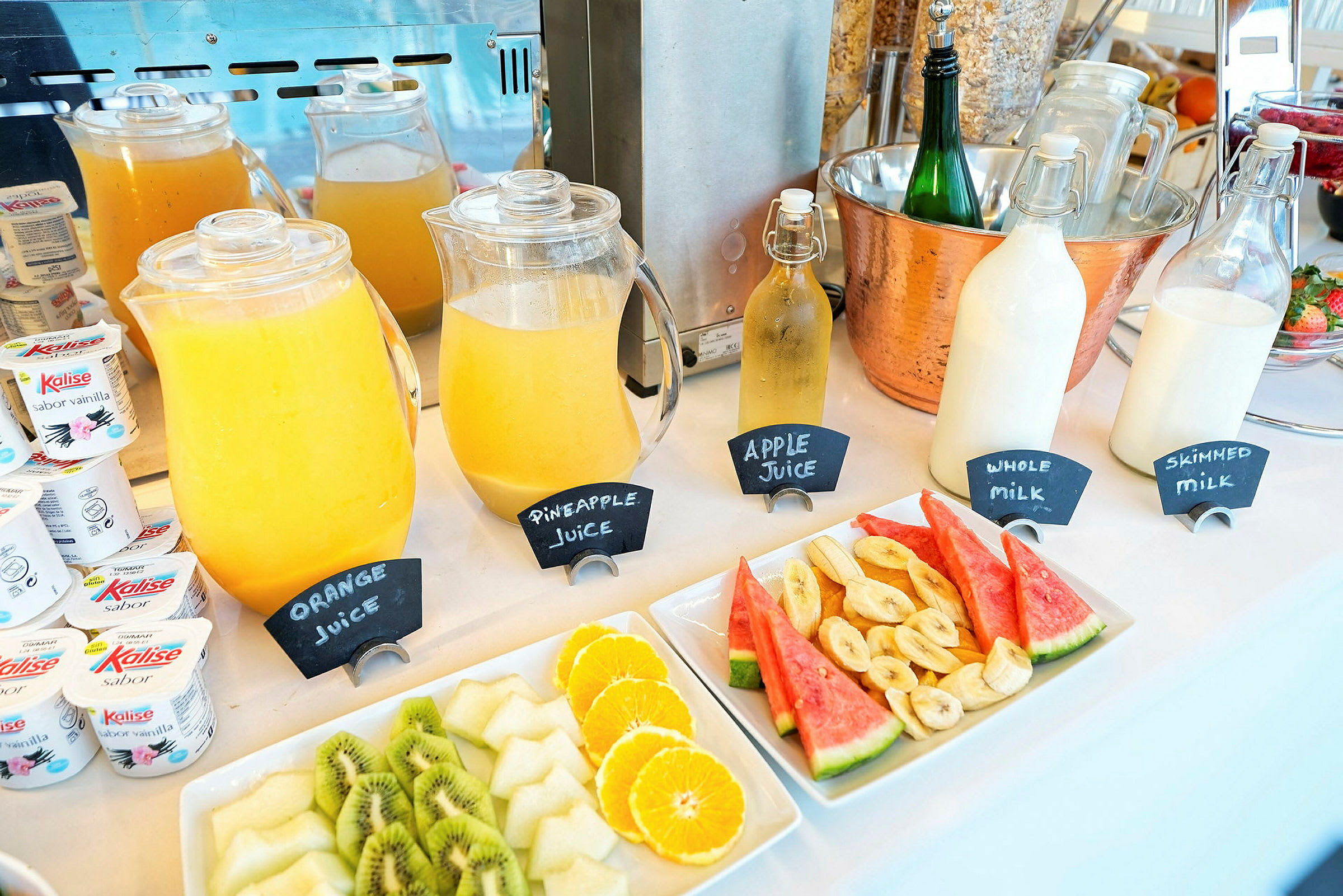 Frokostbuffet med drikker og fersk frukt. (AI-generert tekst)