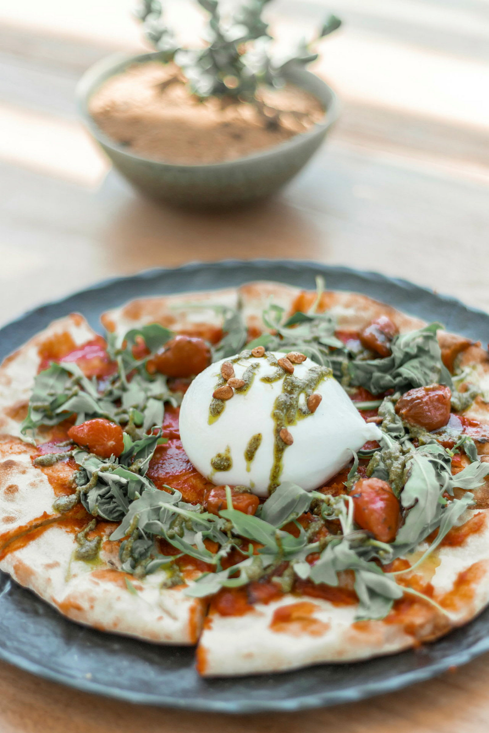 En matrett med burrata og grønnsaker på en bunn. (AI-generert tekst)