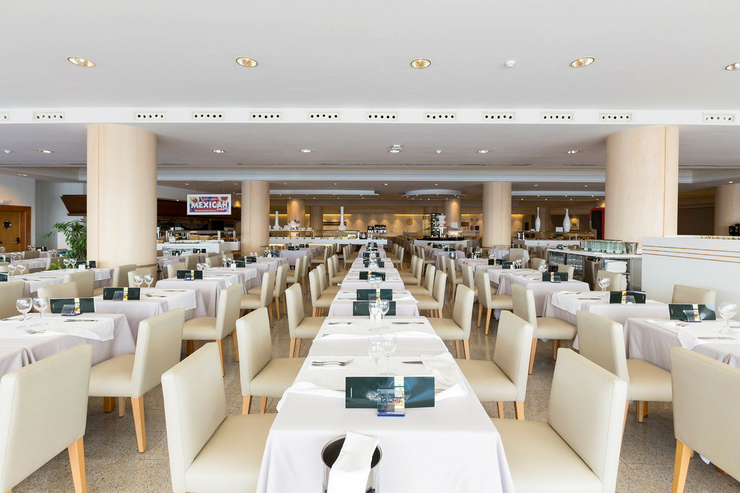 Interiør av en restaurant med dekkede bord og stoler arrangert i rekker. (AI-generert tekst)