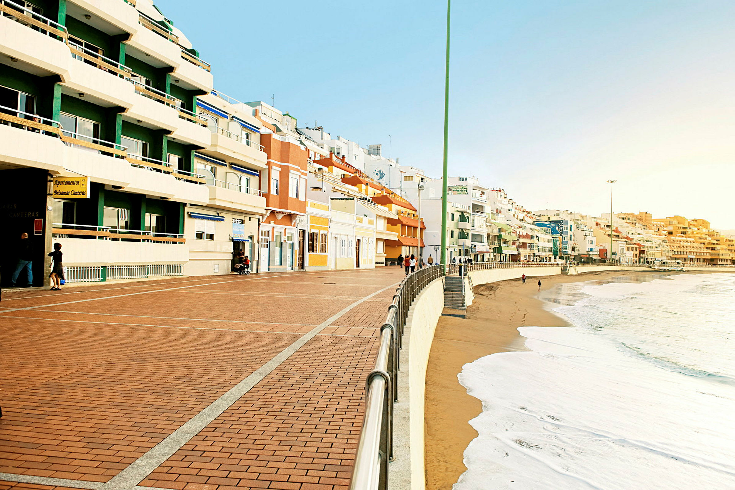 En strandpromenade med fargerike bygninger langs kysten. (AI-generert tekst)