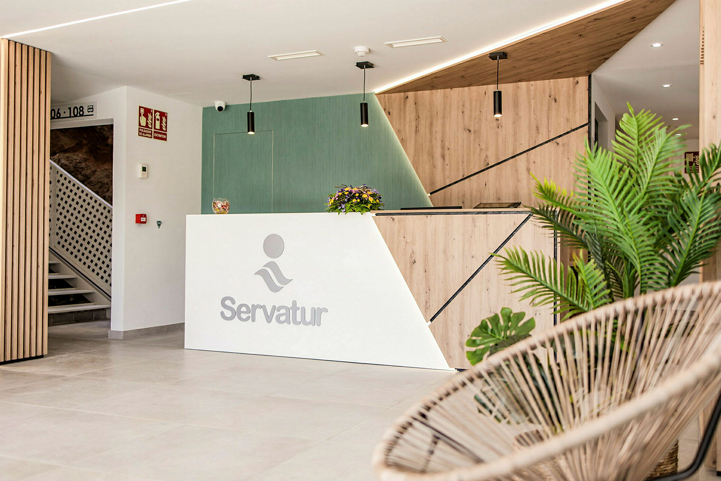 Resepsjon med Servatur-logo, moderne design og dekorative planter. (AI-generert tekst)