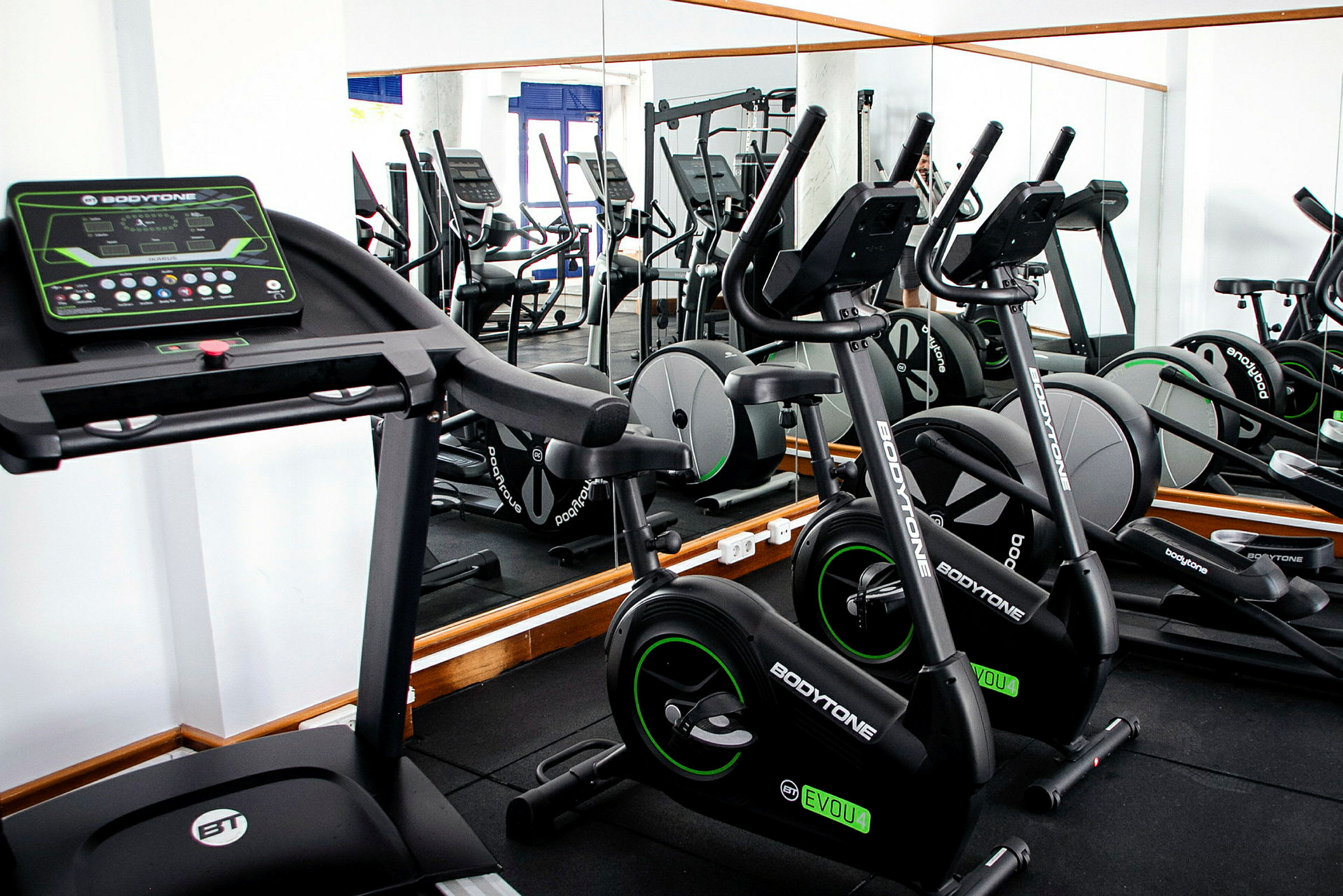 Gym med treningsmaskiner, inkludert tredemølle og treningssykkel. (AI-generert tekst)