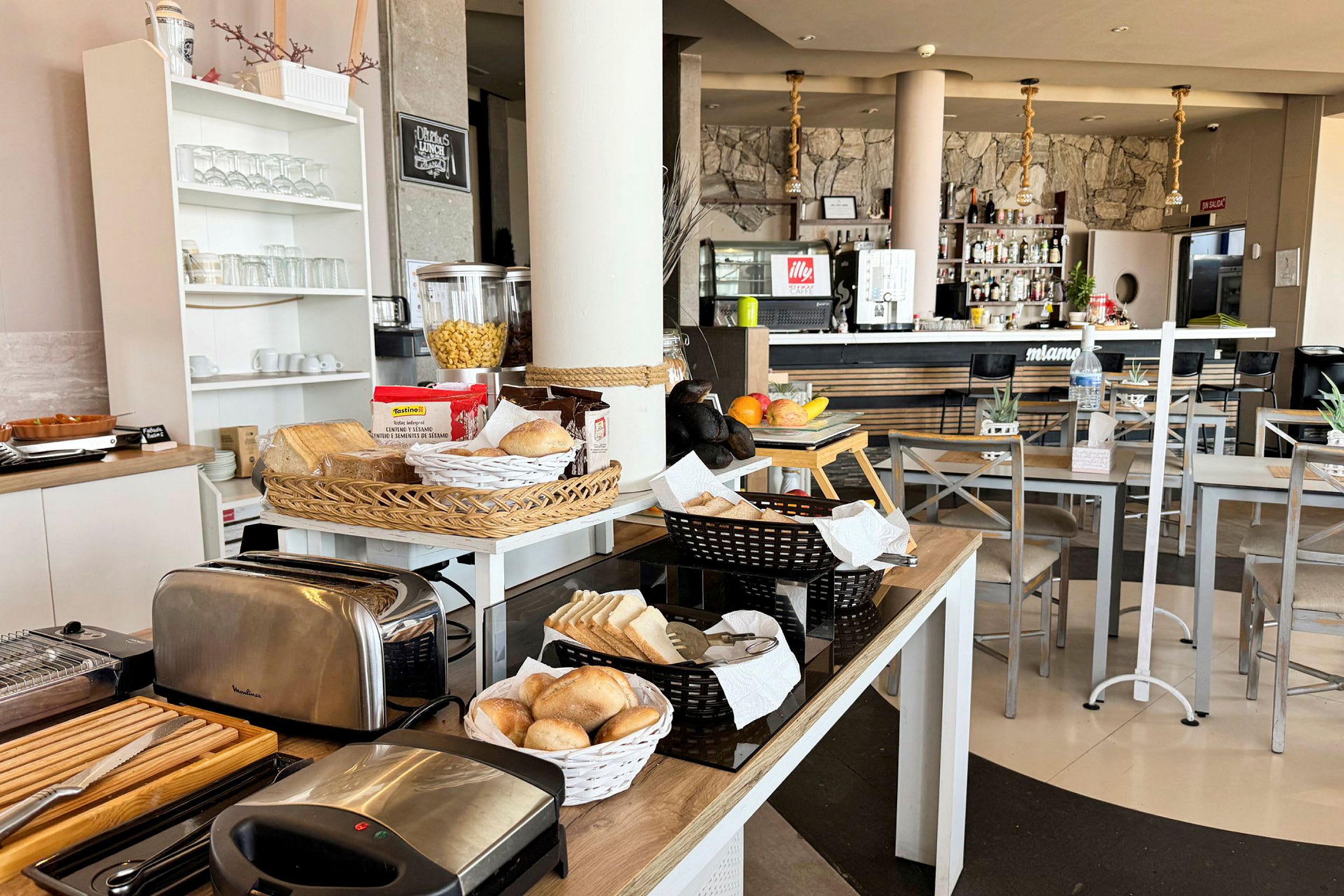 Frokostbuffé med brød og brødrister i et lyst kafémiljø. (AI-generert tekst)