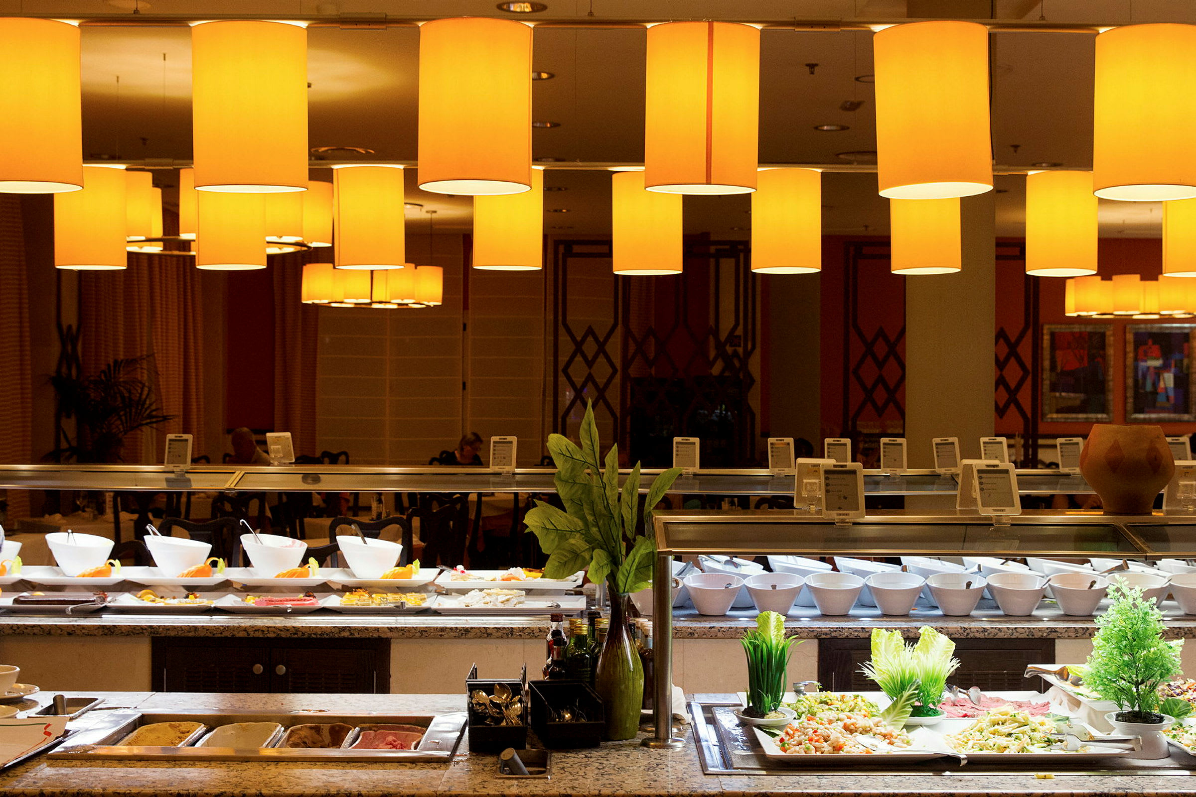 Buffet med ulike retter presentert under opplyste taklamper. (AI-generert tekst)