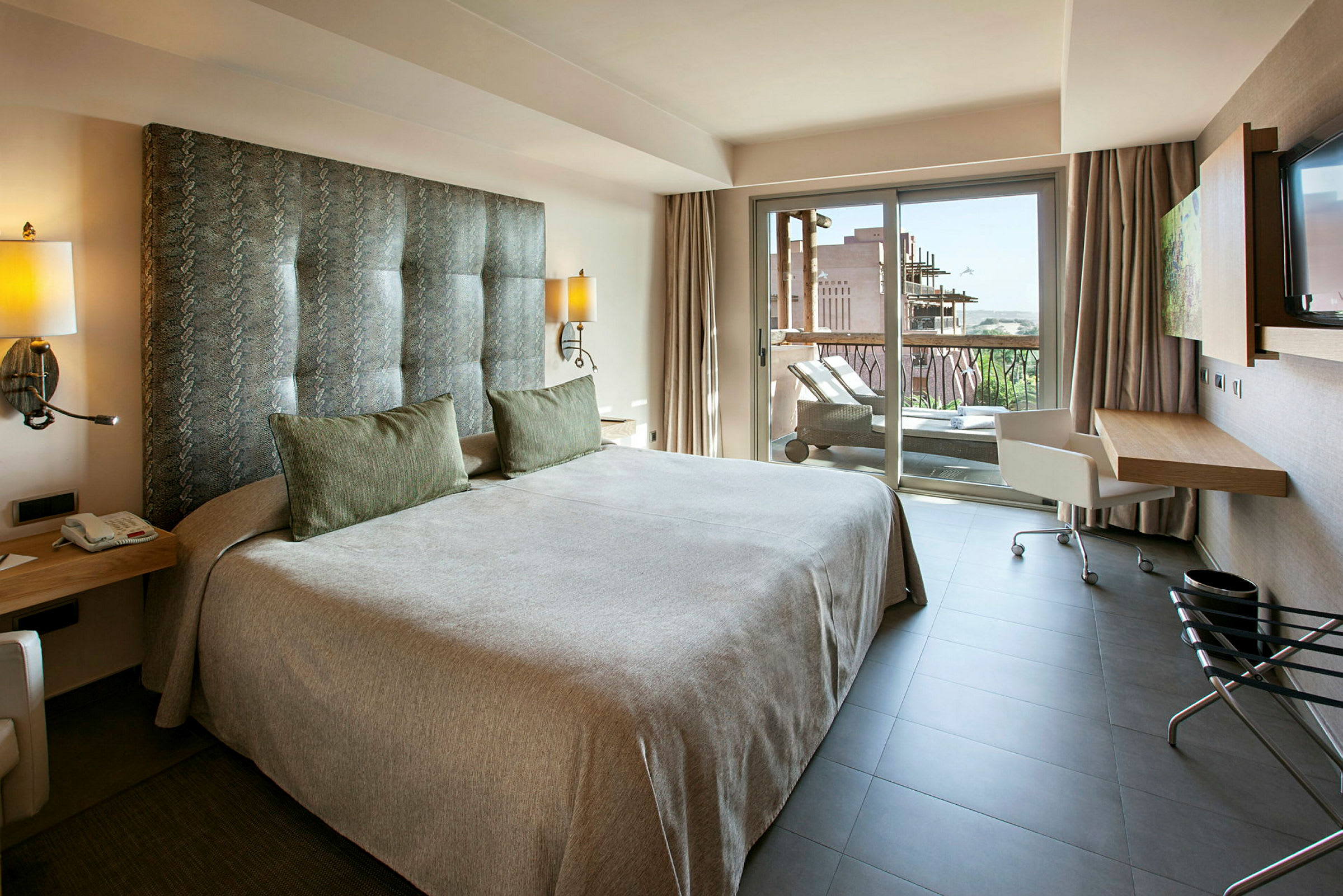 Moderne hotellrom med en dobbeltseng og tilgang til en balkong. (AI-generert tekst)