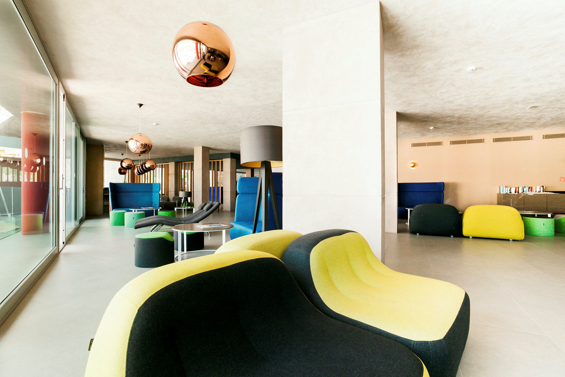 Moderne lounge med fargerike møbler og kobberfargede lamper. (AI-generert tekst)