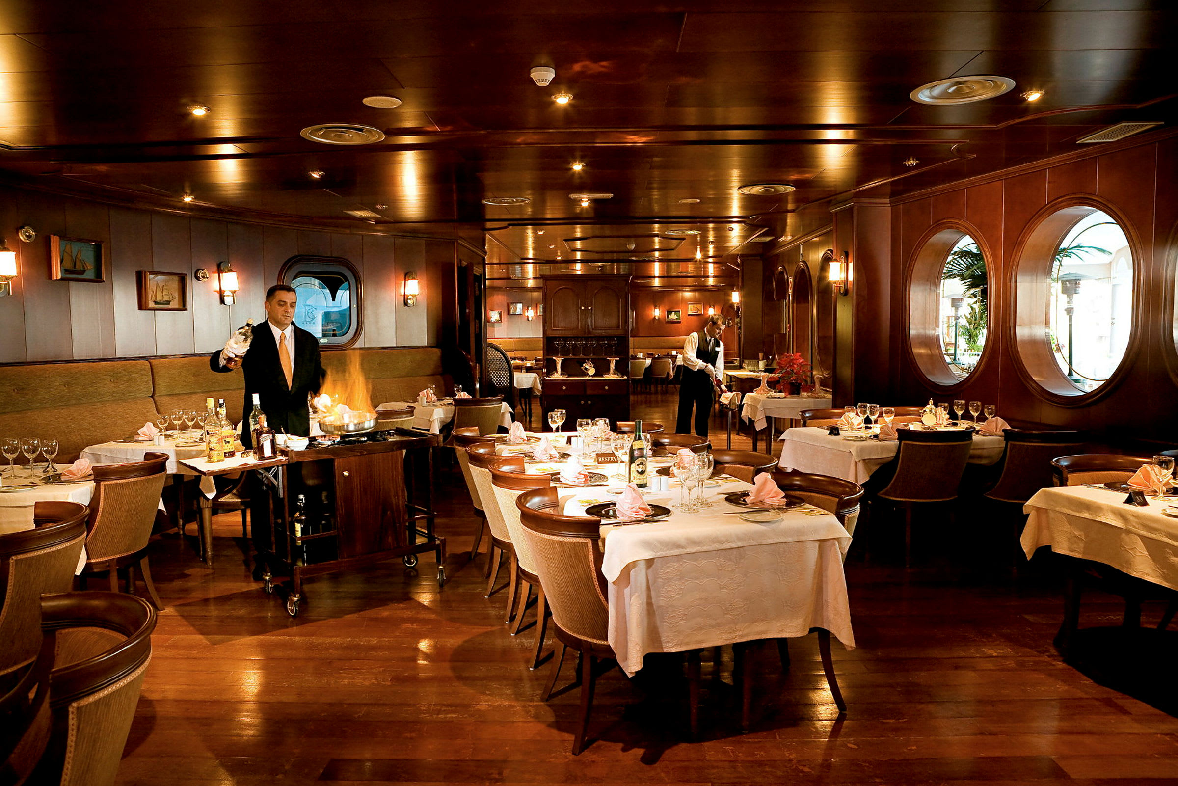 Interiør av en elegant restaurant med dekkede bord og trepaneler. (AI-generert tekst)