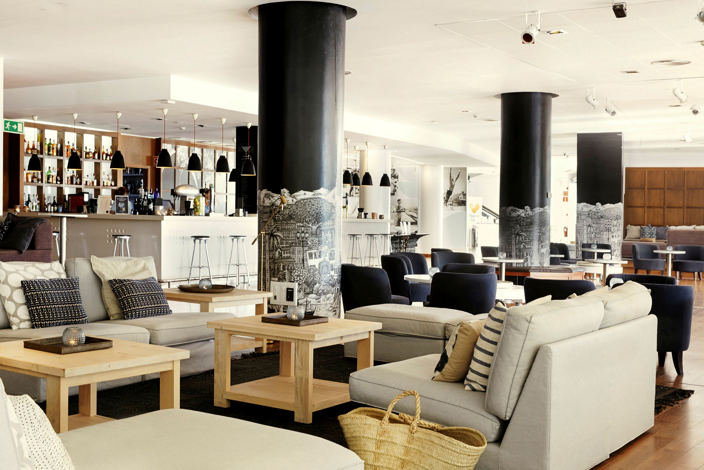 Lyst og moderne loungeområde med sittegrupper og en bar. (AI-generert tekst)