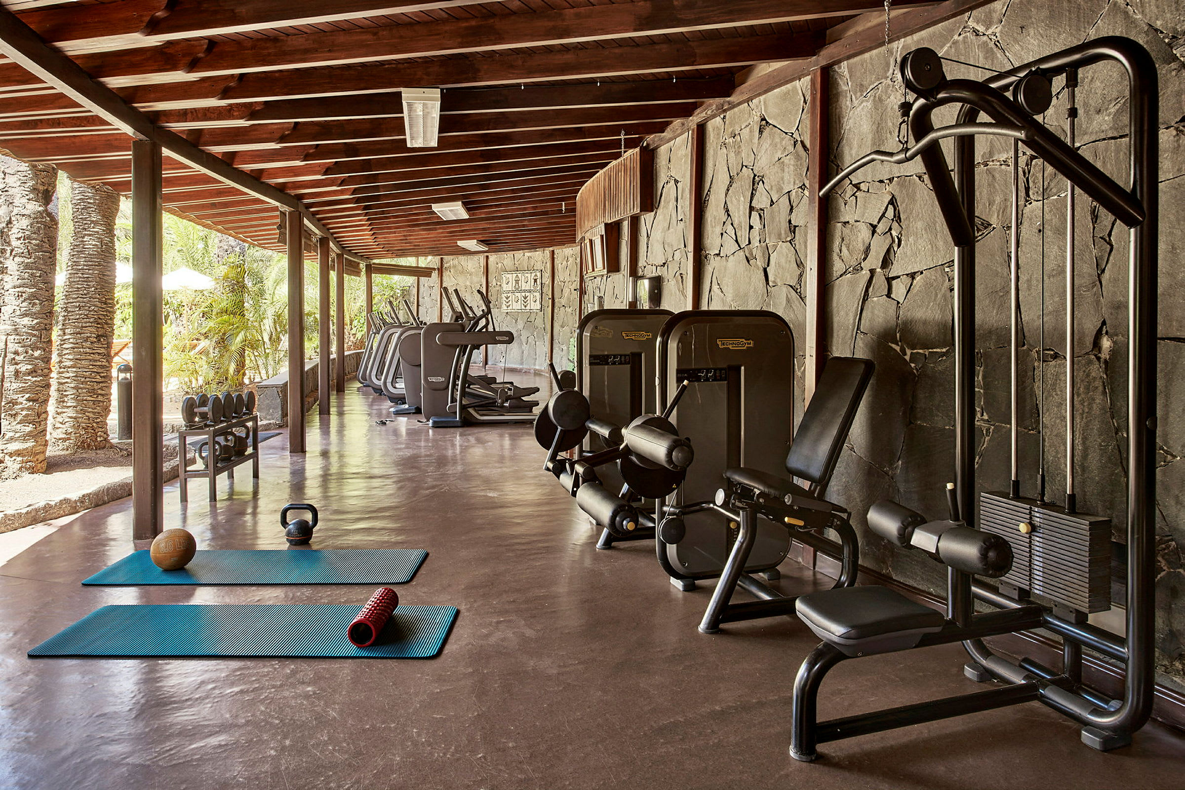 Et åpent treningsstudio med treningsmaskiner, treningsmatter og vekter. (AI-generert tekst)