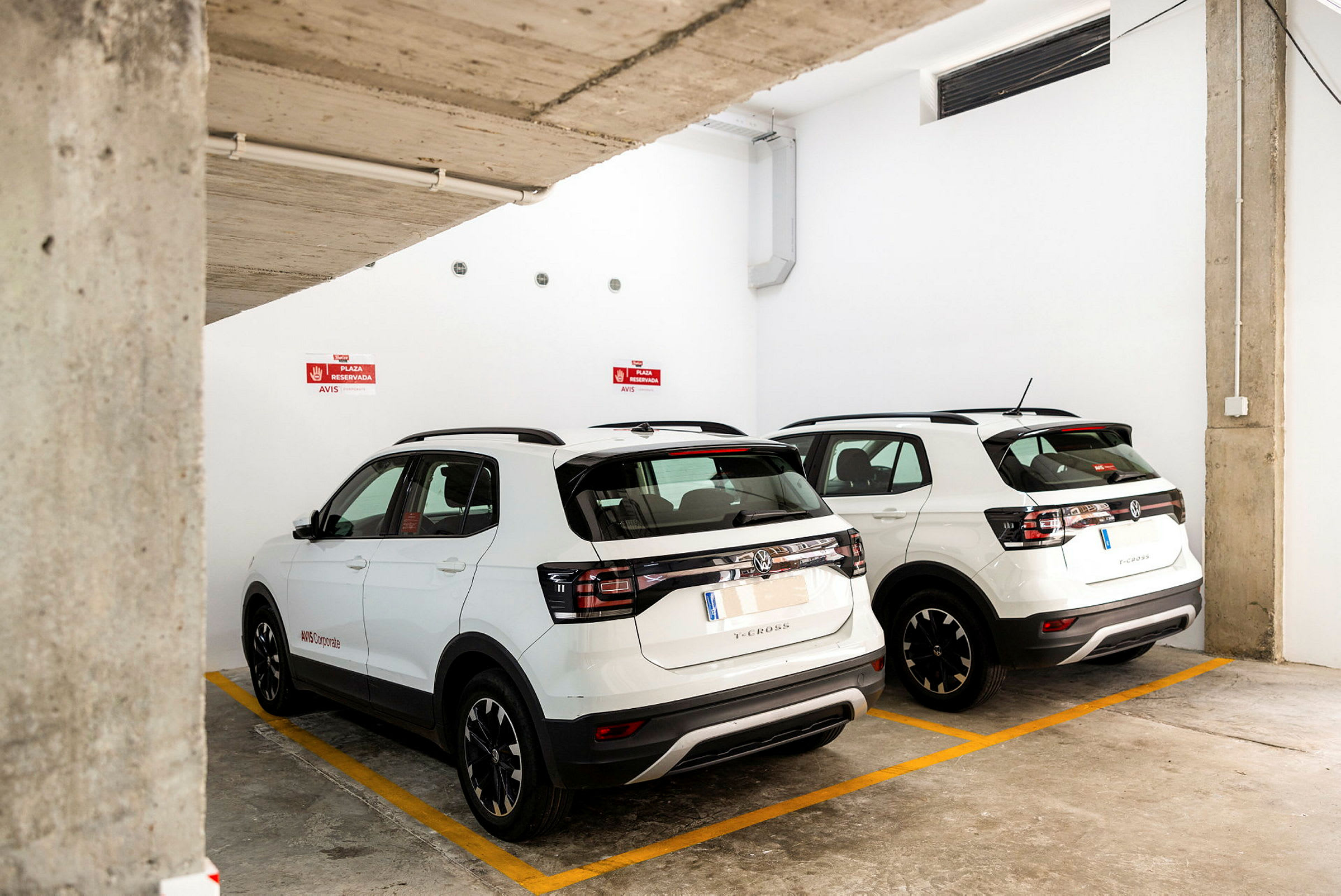 To hvite SUV-biler parkert i en underjordisk parkeringsplass. (AI-generert tekst)