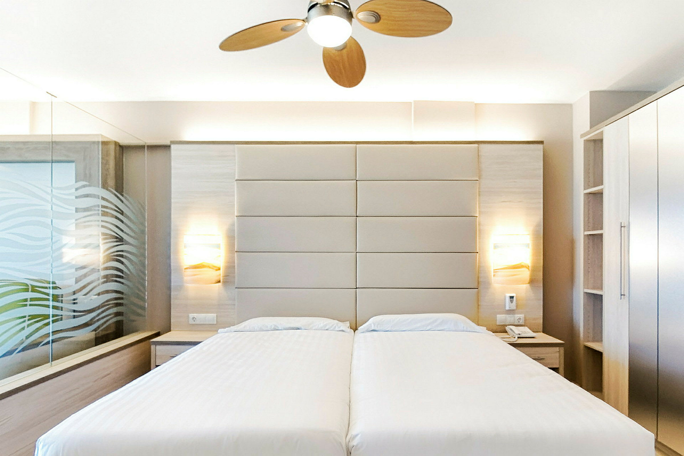 Hotellrom med to enkeltsenger, moderne innredning og takvifte. (AI-generert tekst)