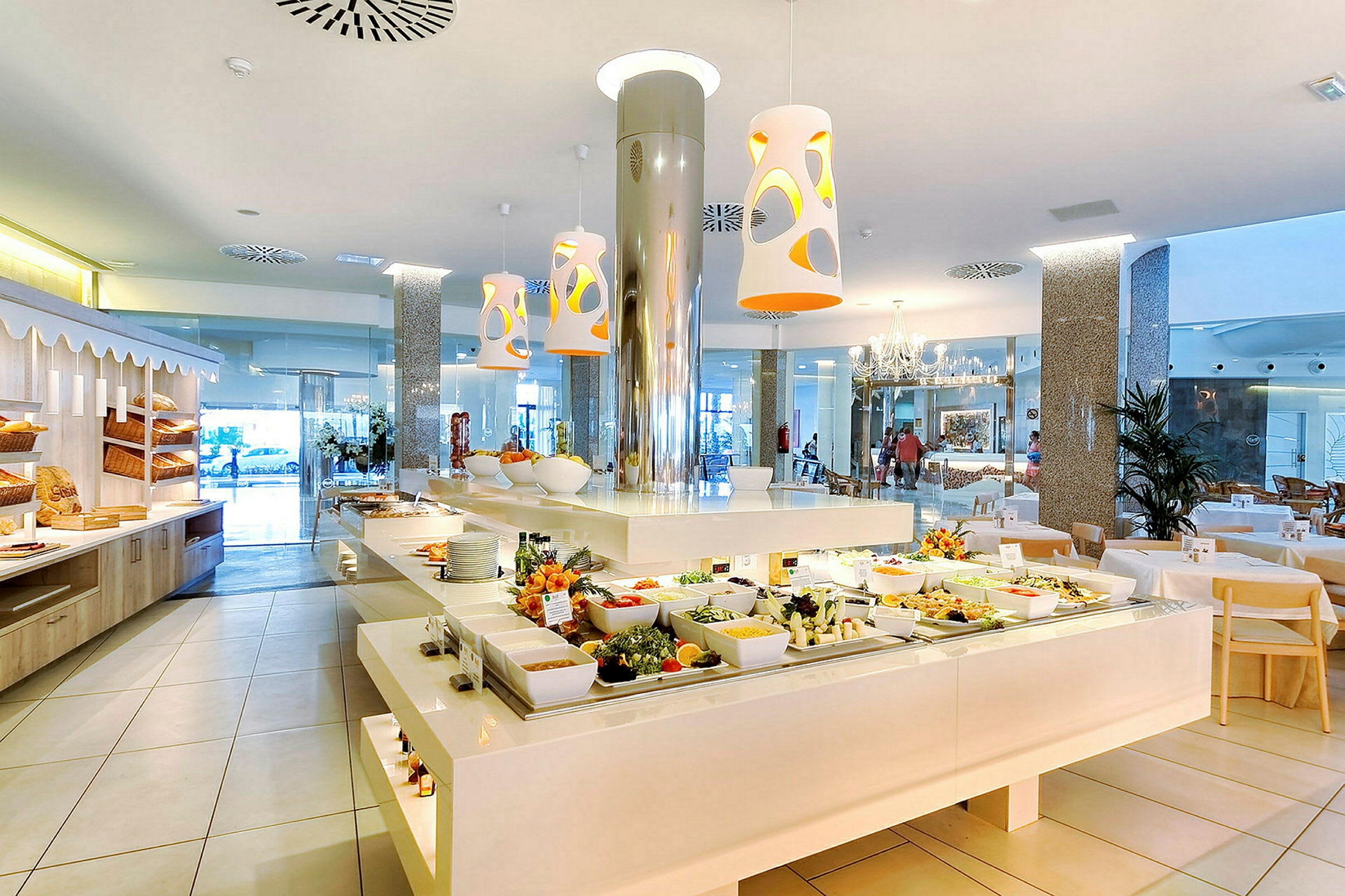 En lys restaurant med en buffé full av ulike matretter og salatingredienser. Moderne interiør og store vinduer i bakgrunnen. (AI-generert tekst)