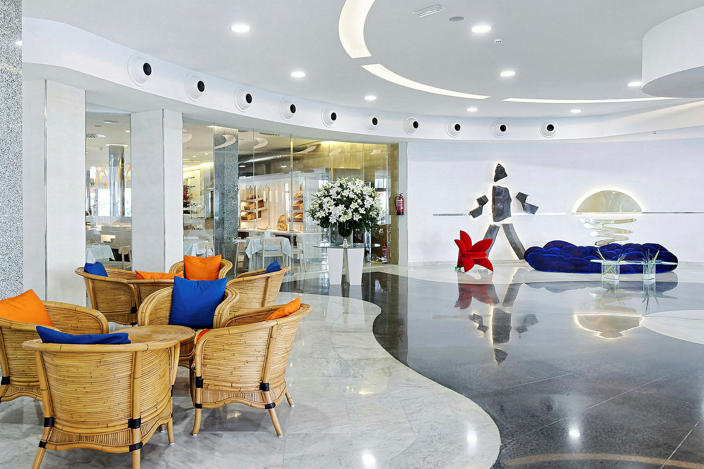 Moderne innredet hotellobby med sittegruppe, dekorative elementer og blomster. (AI-generert tekst)