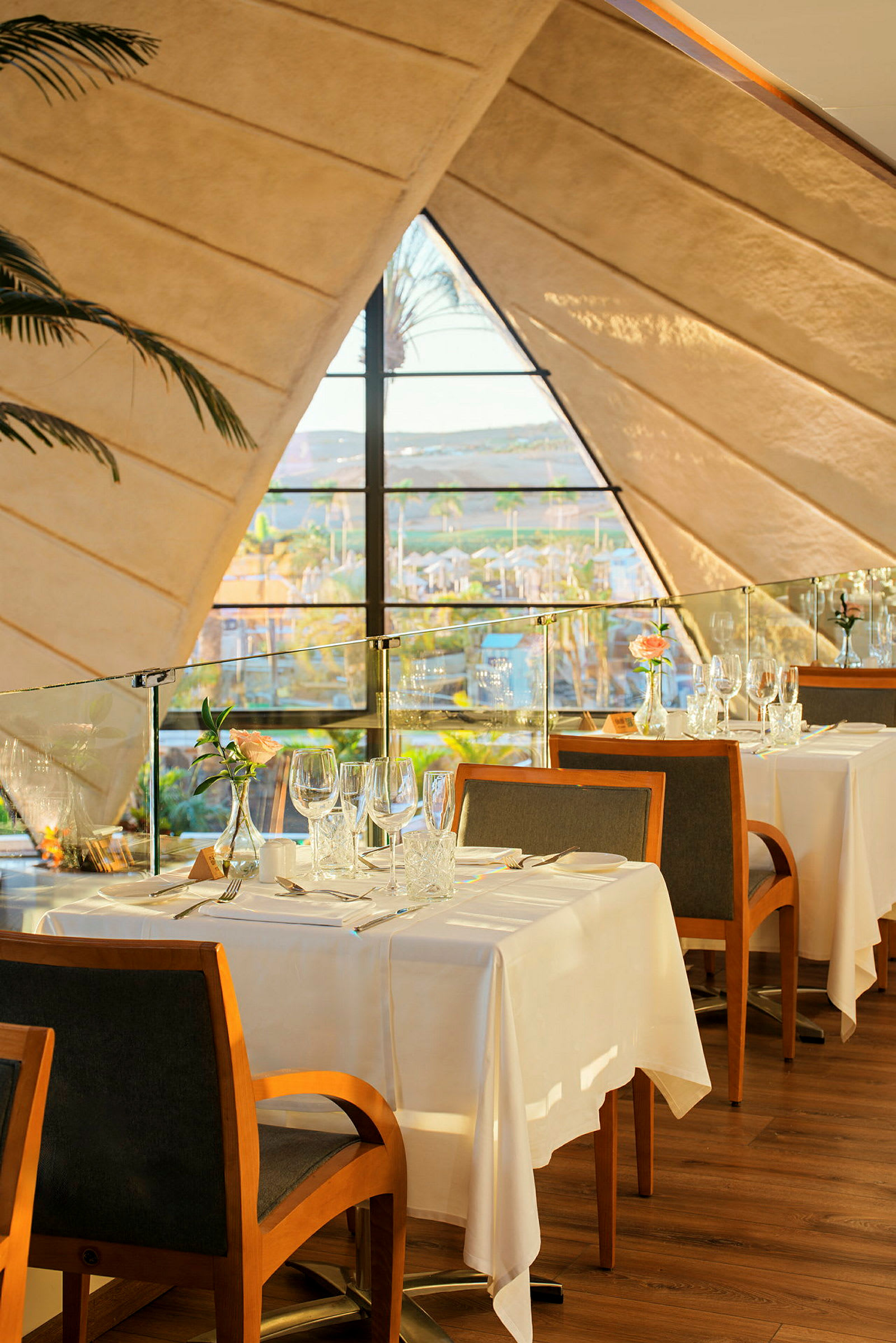 Restaurant med dekket bord ved siden av et stort vindu med sollys. (AI-generert tekst)