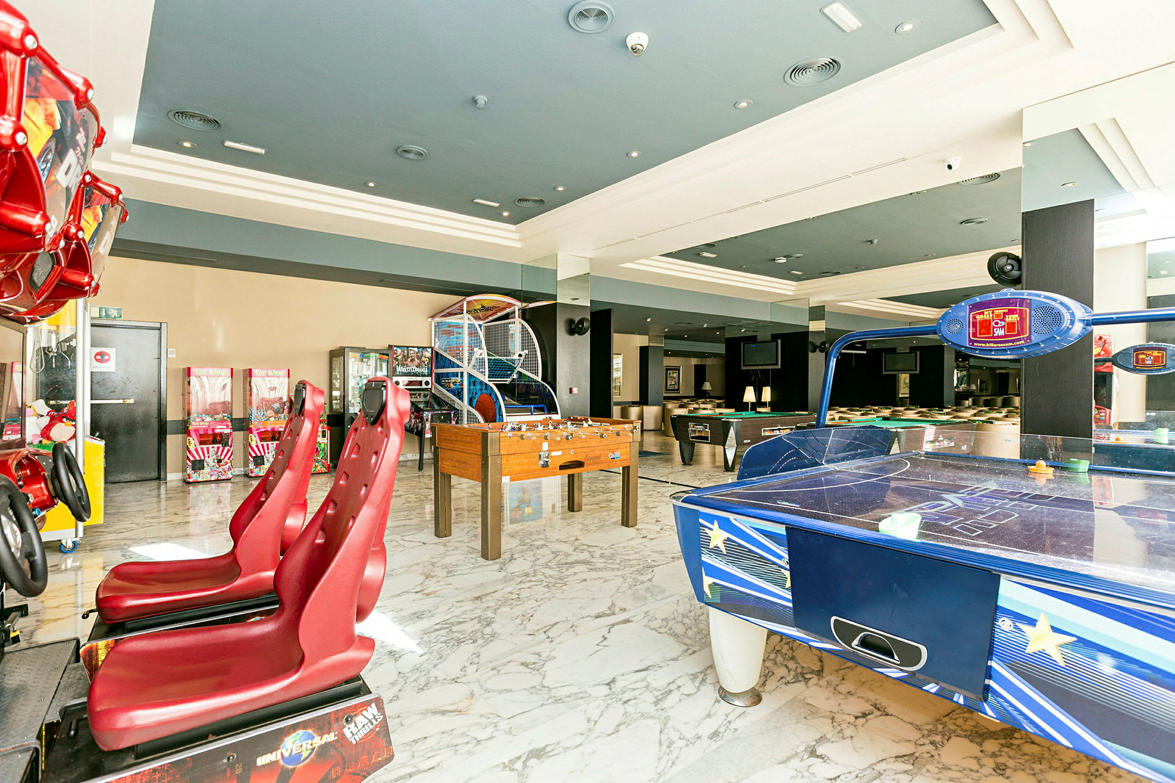 Bilde av et spillerom med ulike arkadespill, bordfotball og air hockey. (AI-generert tekst)