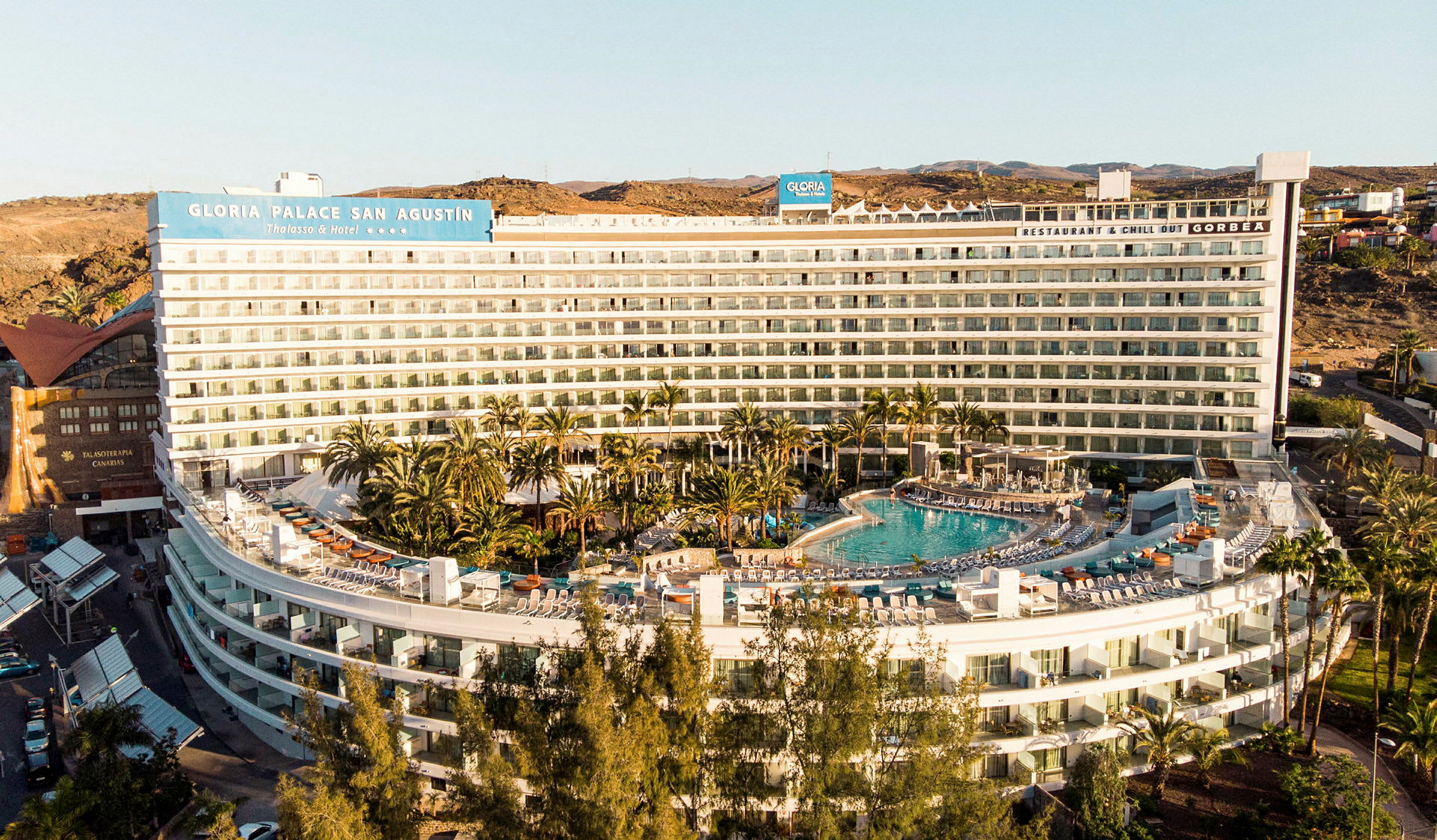 Hotellbygning med basseng og omkringliggende grøntareal. (AI-generert tekst)