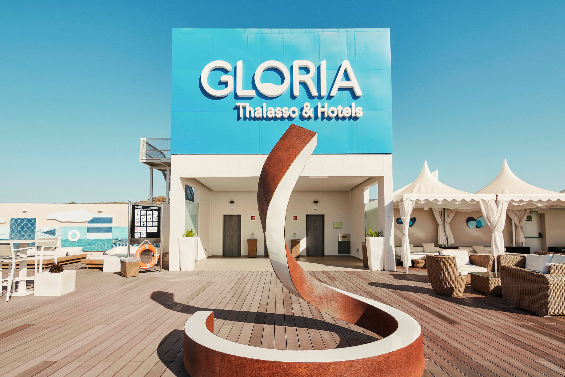 Utendørsområde ved Gloria Thalasso & Hotels med moderne skulptur og sitteplasser. (AI-generert tekst)