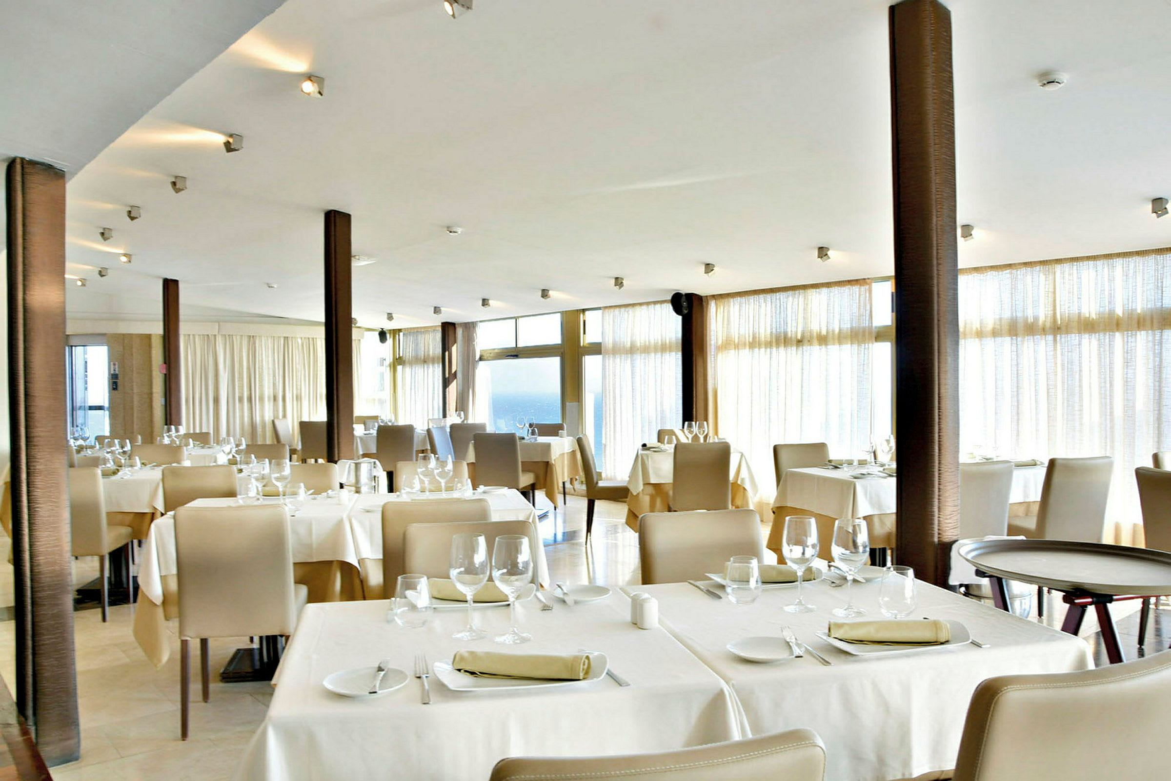 Bilde av en restaurant med dekkede bord og stoler. (AI-generert tekst)