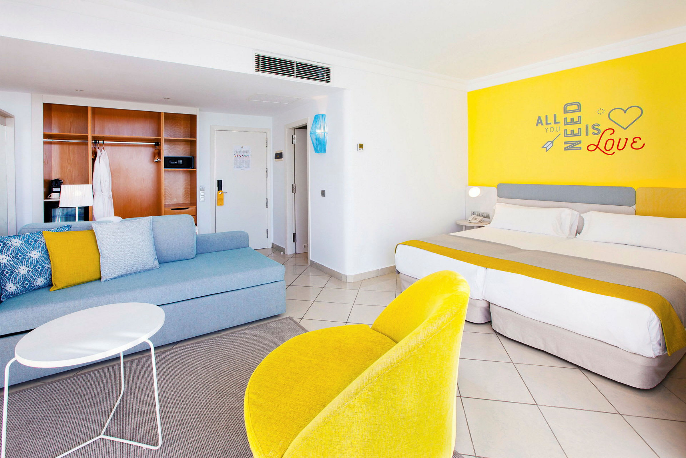 Hotellrom med moderne innredning, inkludert en seng, sittegruppe og fargerike detaljer. (AI-generert tekst)