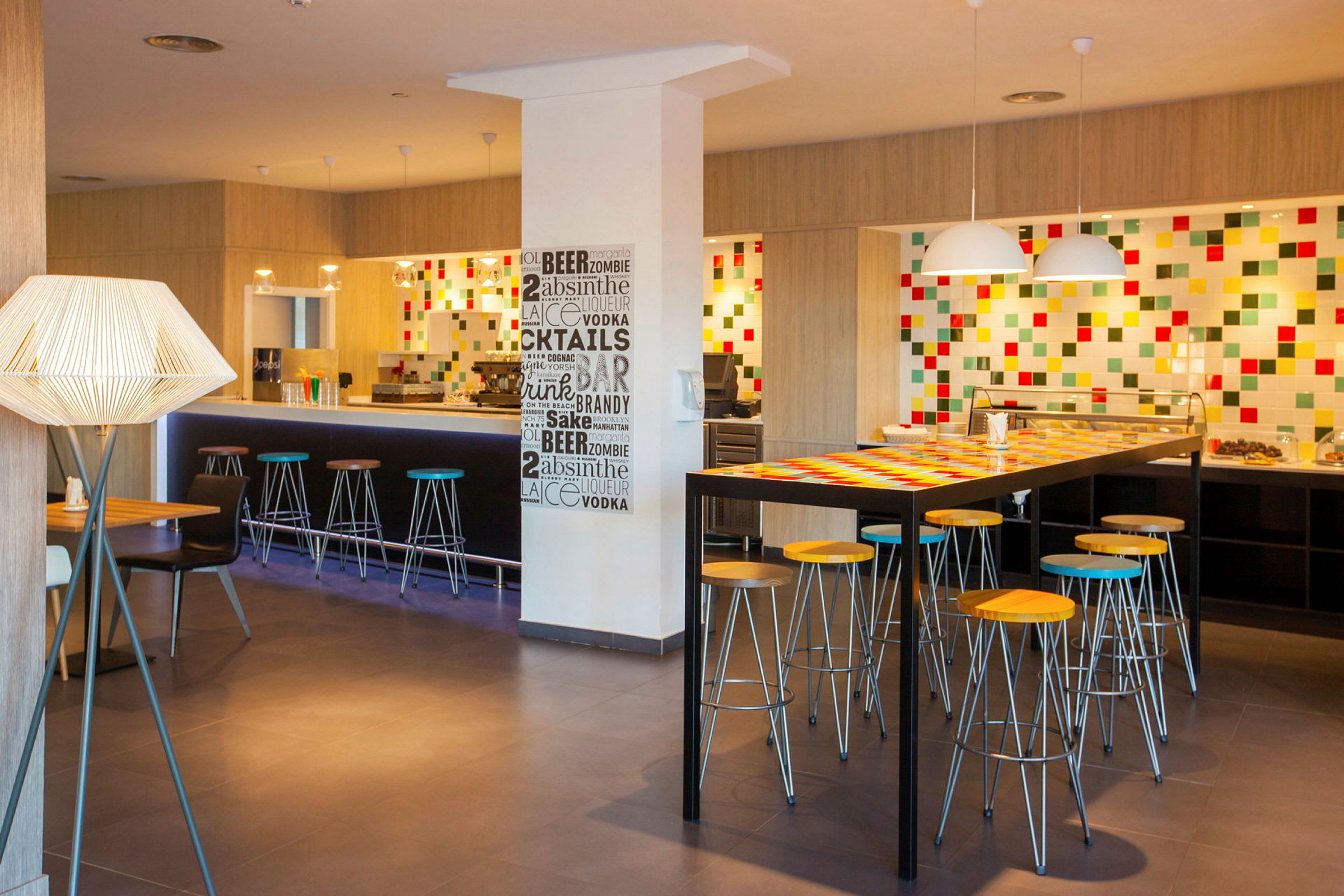 En moderne bar med høye stoler og fargerikt veggdekor. (AI-generert tekst)