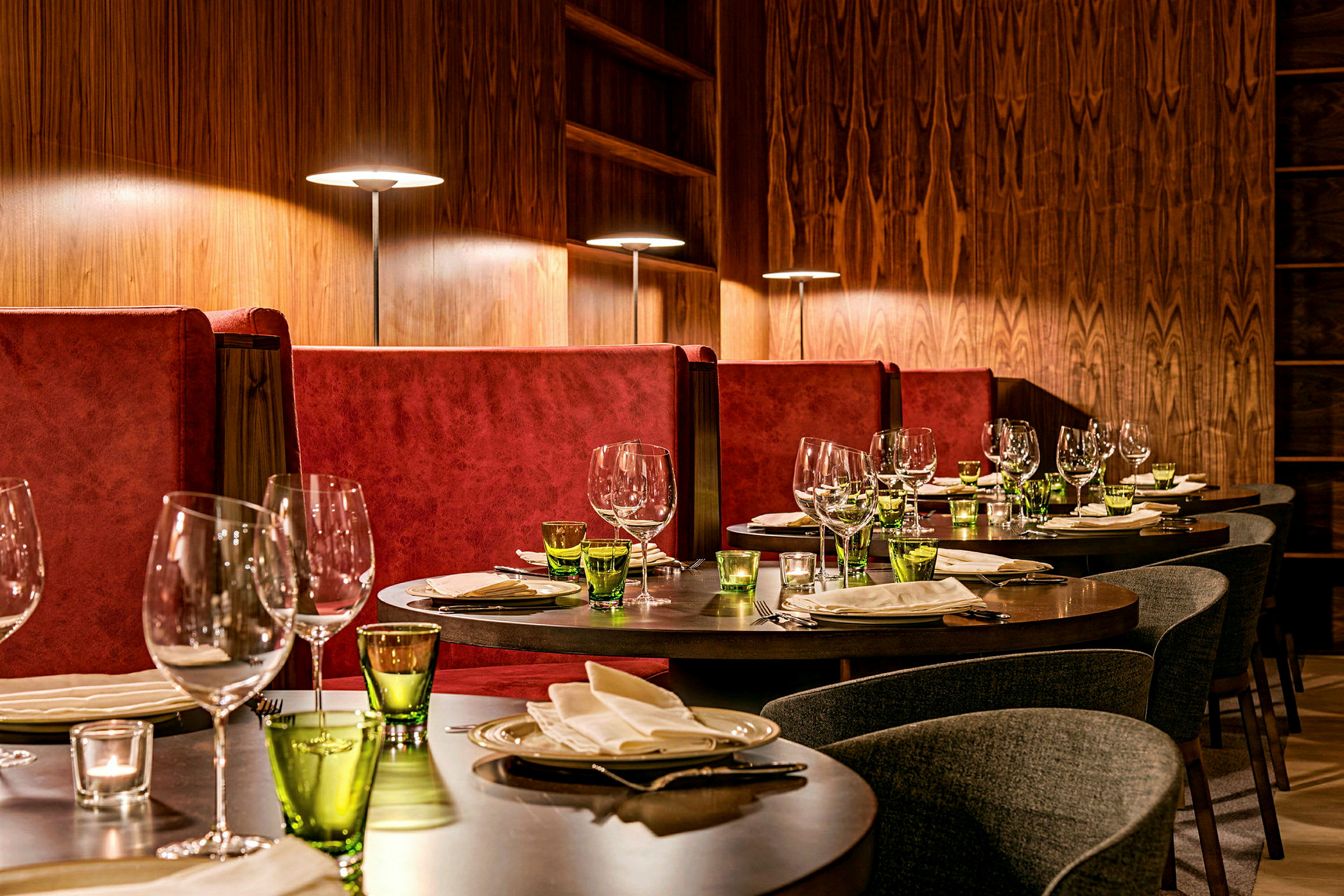 Elegant restaurant med dekte bord og røde sofaer. (AI-generert tekst)