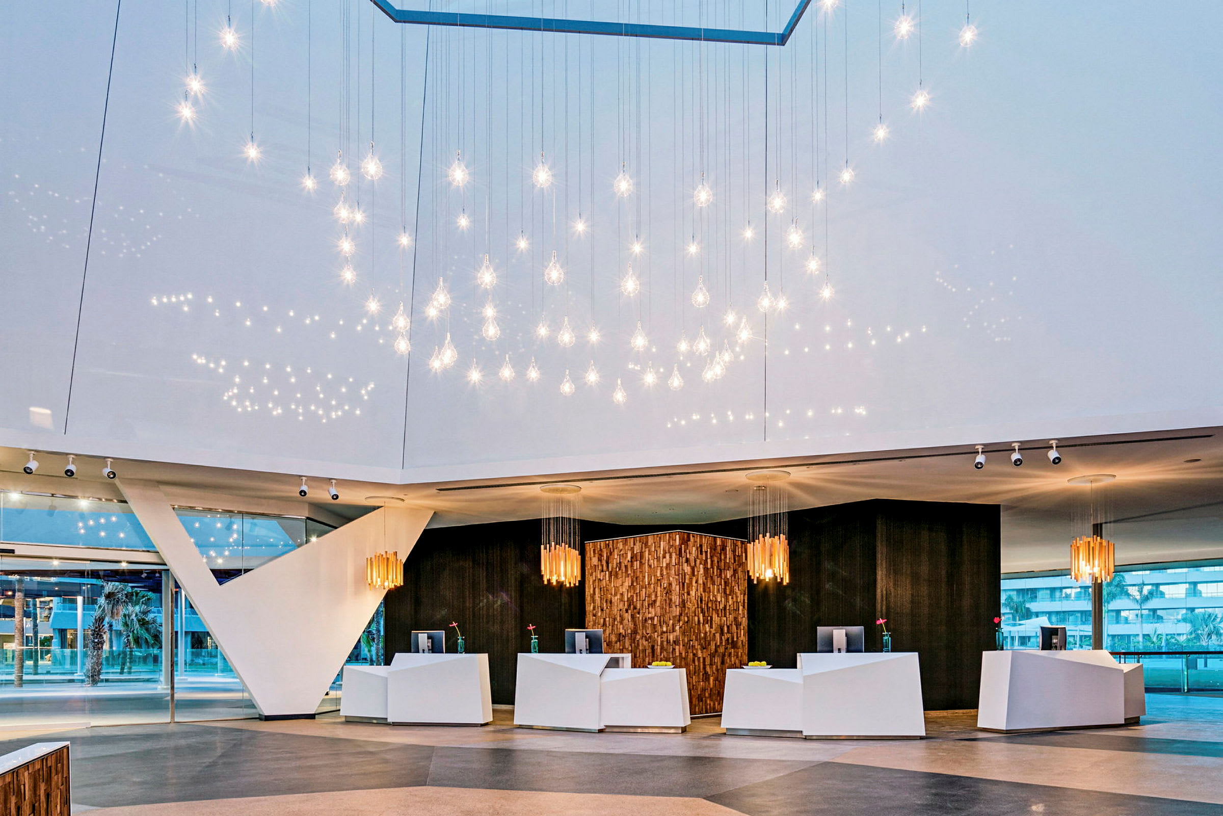 Hotellets lobby med moderne innredning og hengende lysdekorasjoner. (AI-generert tekst)