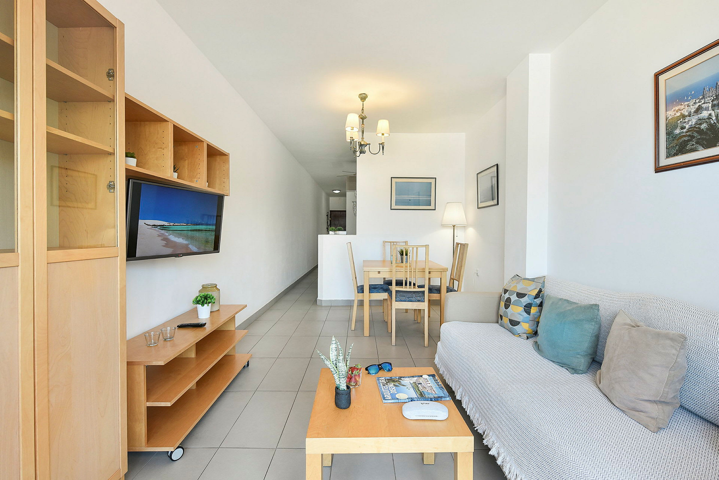 En stue med sofa, salongbord, spisebord og TV. (AI-generert tekst)