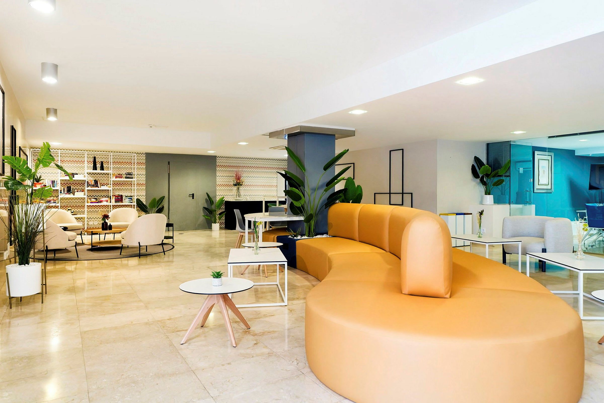 En lys og moderne salong med en stor gul sofa, bord og frodige planter. (AI-generert tekst)