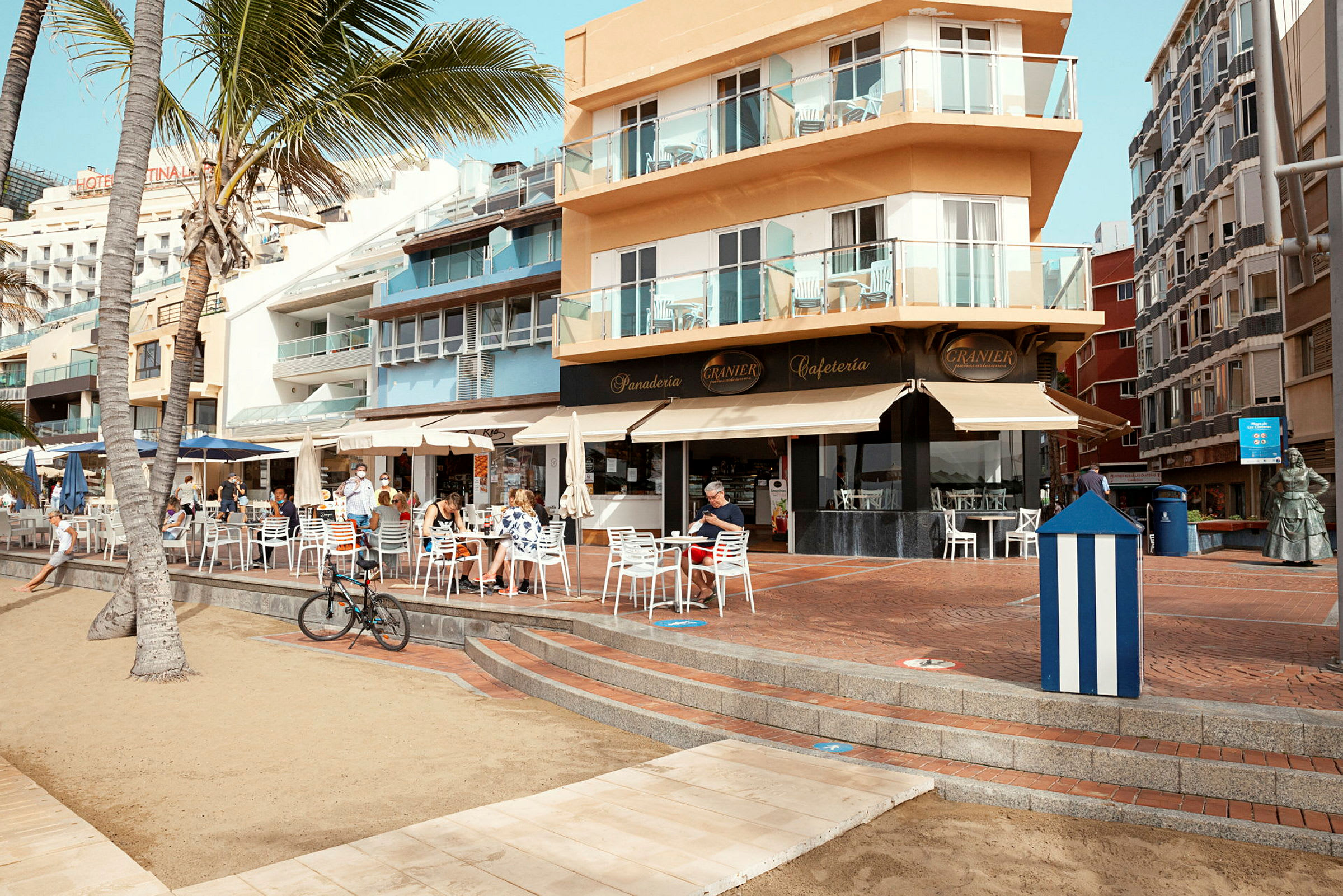 Kafé og bygning ved en strandpromenade. (AI-generert tekst)