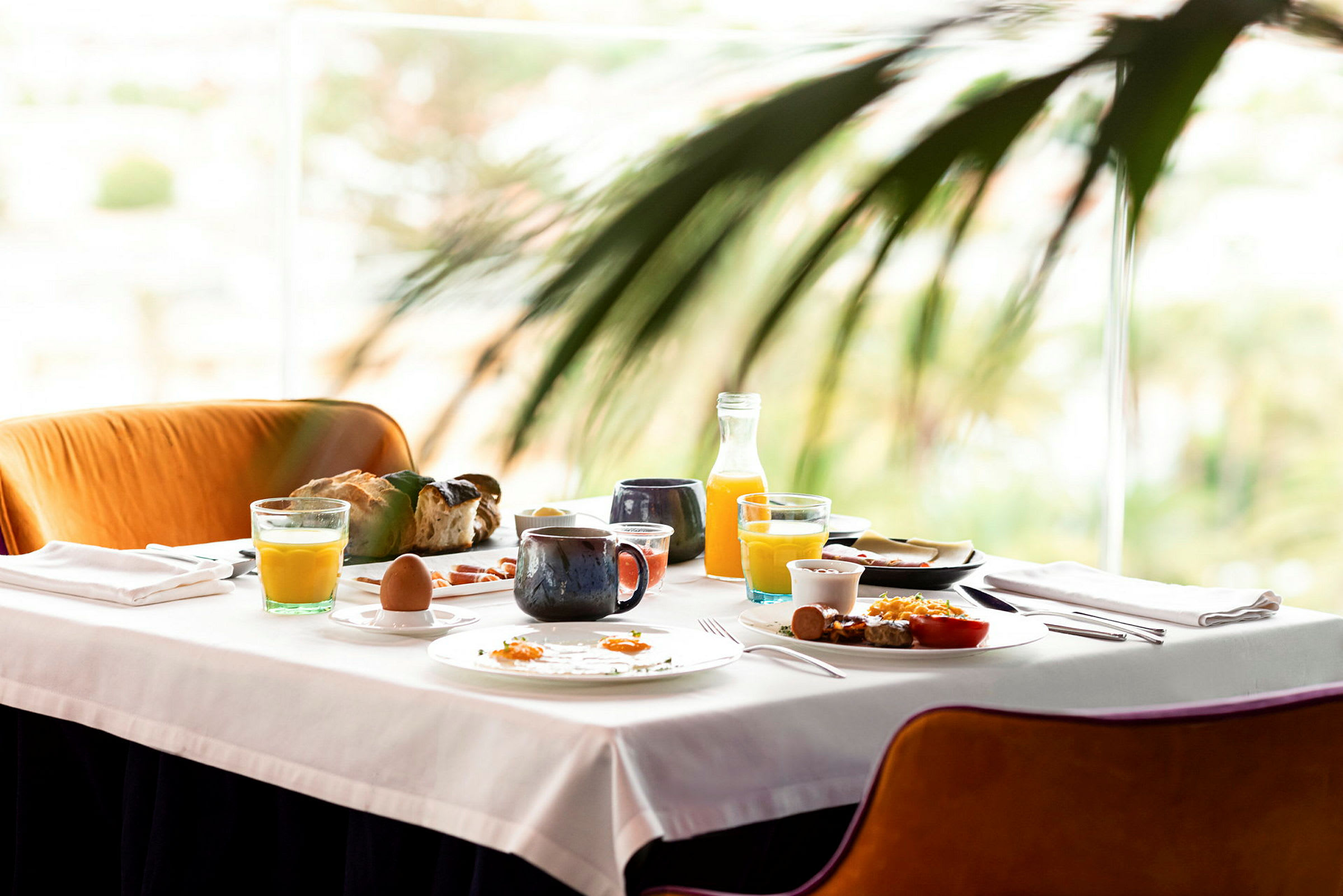 Et bord dekket med frokostmat, inkludert juice, kaffe, brød og egg. (AI-generert tekst)