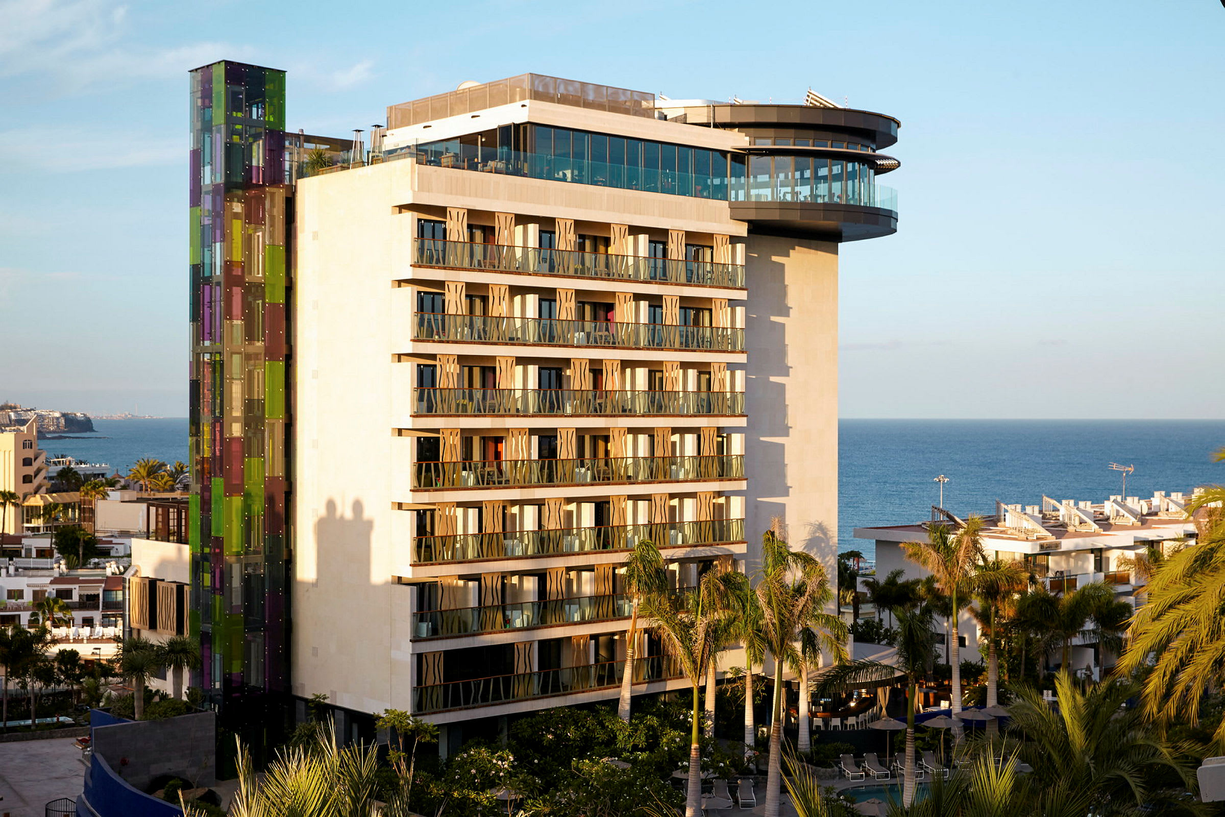 Moderne hotellbygning med havet i bakgrunnen. (AI-generert tekst)