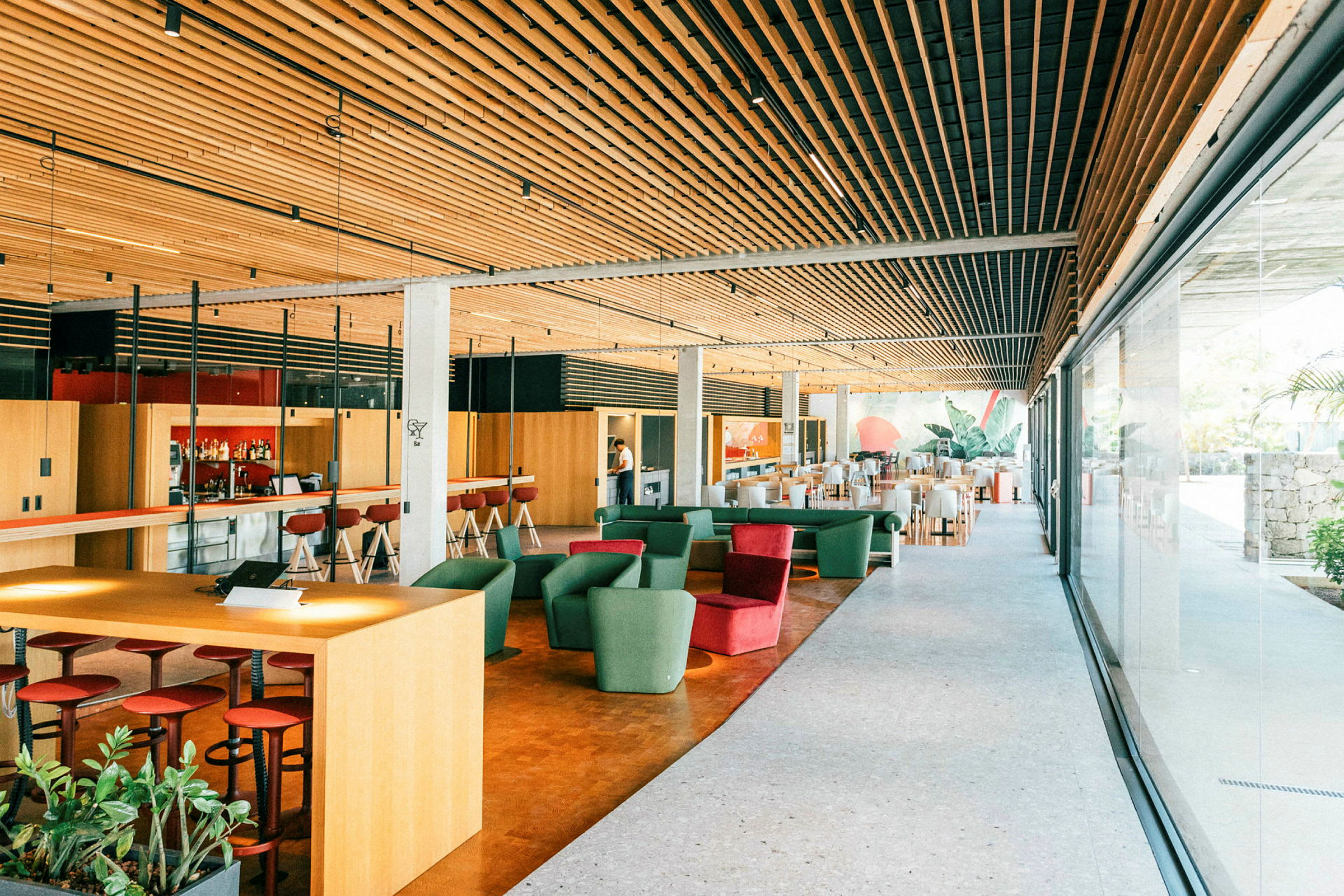 Interiør av en moderne lounge med sitteplasser, barområde og store vinduer. (AI-generert tekst)