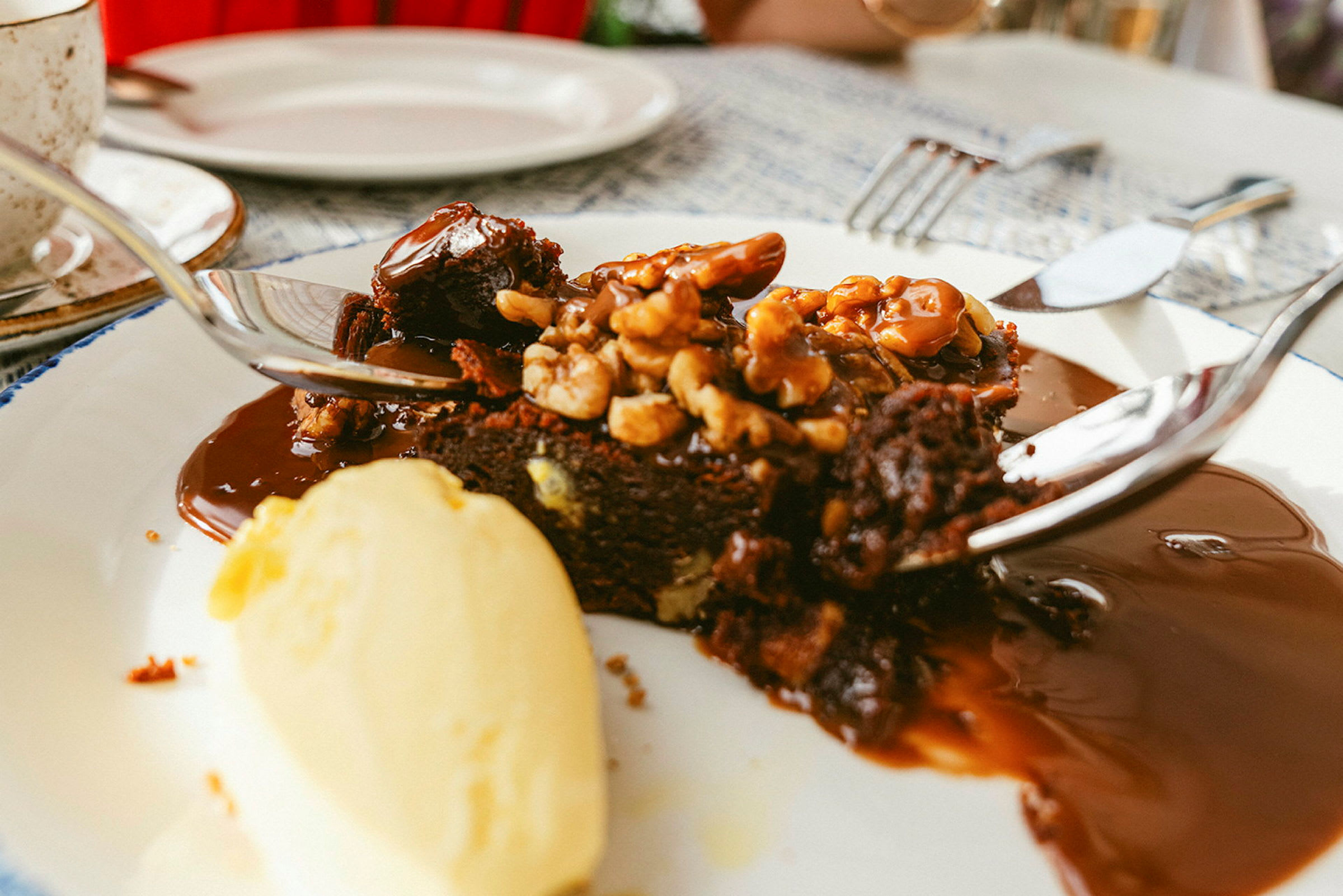 Sjokoladekake servert med nøtter, saus og vaniljeis. (AI-generert tekst)