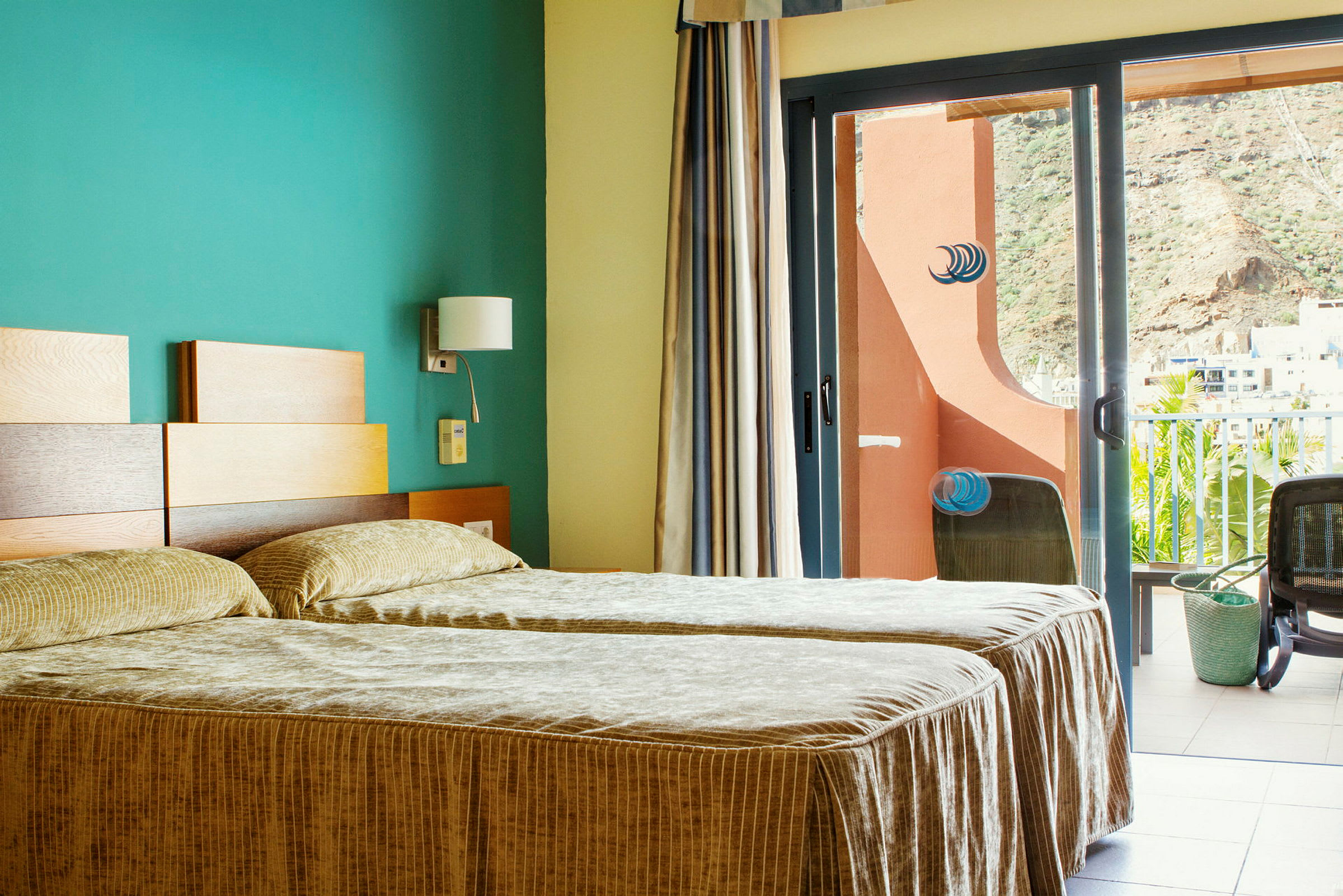 Hotellrom med to enkeltsenger og en balkong med utsikt. (AI-generert tekst)