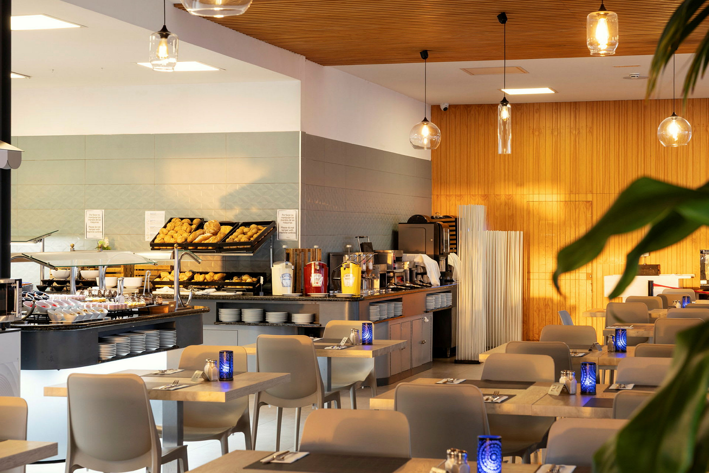 Et moderne hotellfrokostområde med oppsett av brød og drikker. (AI-generert tekst)