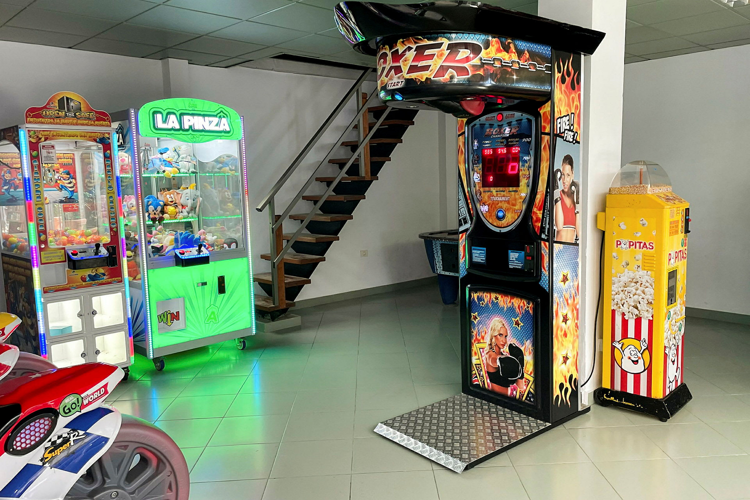 Et rom med forskjellige spillemaskiner, inkludert en boksemaskin, klospill og en popkornautomat. (AI-generert tekst)