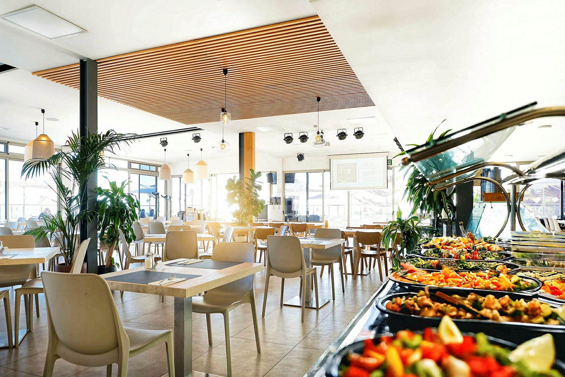 Restaurant med moderne møbler og buffetbord med salater og tilbehør. (AI-generert tekst)