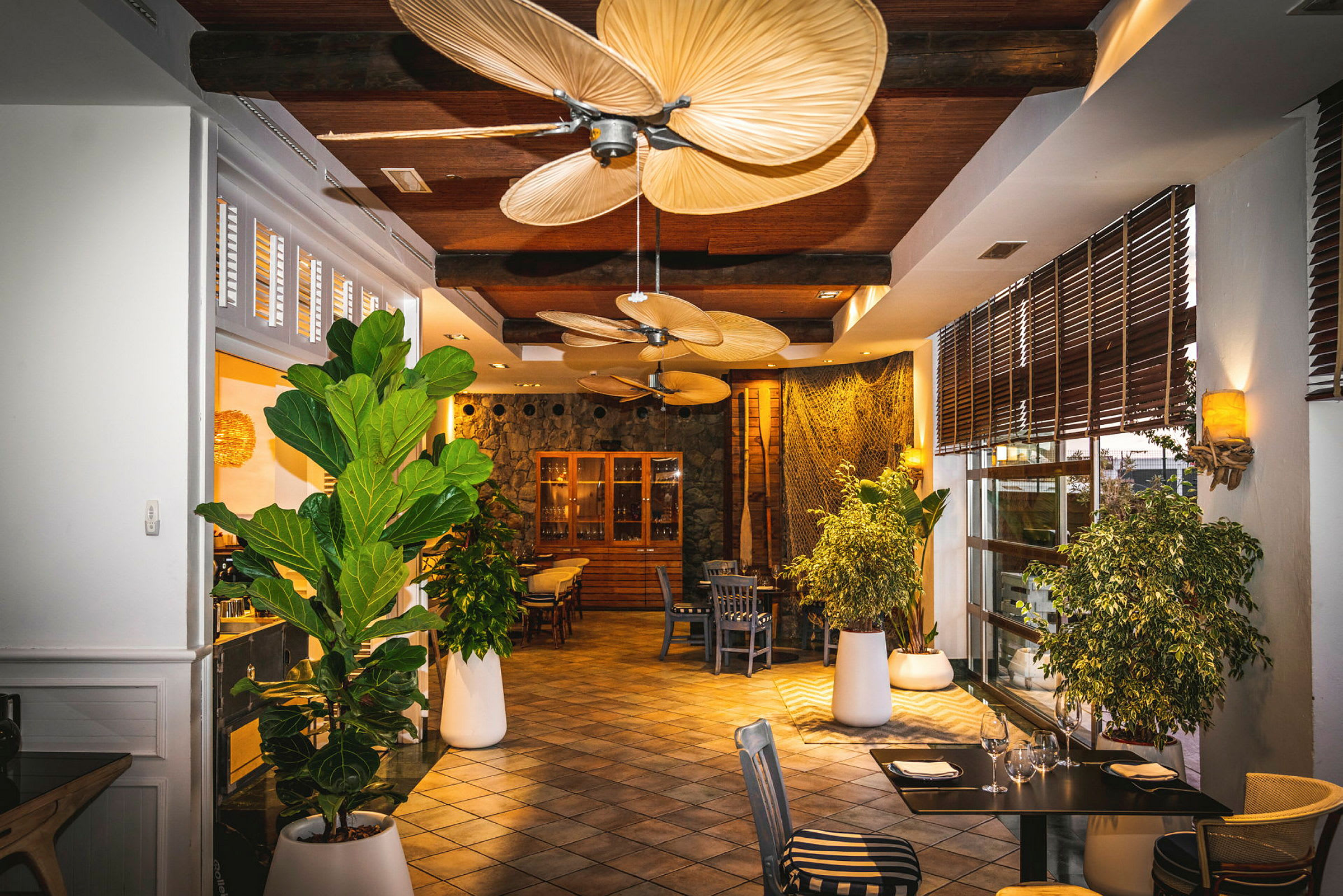 Bilde av en restaurant med grønn planteinnredning og store takvifter. (AI-generert tekst)