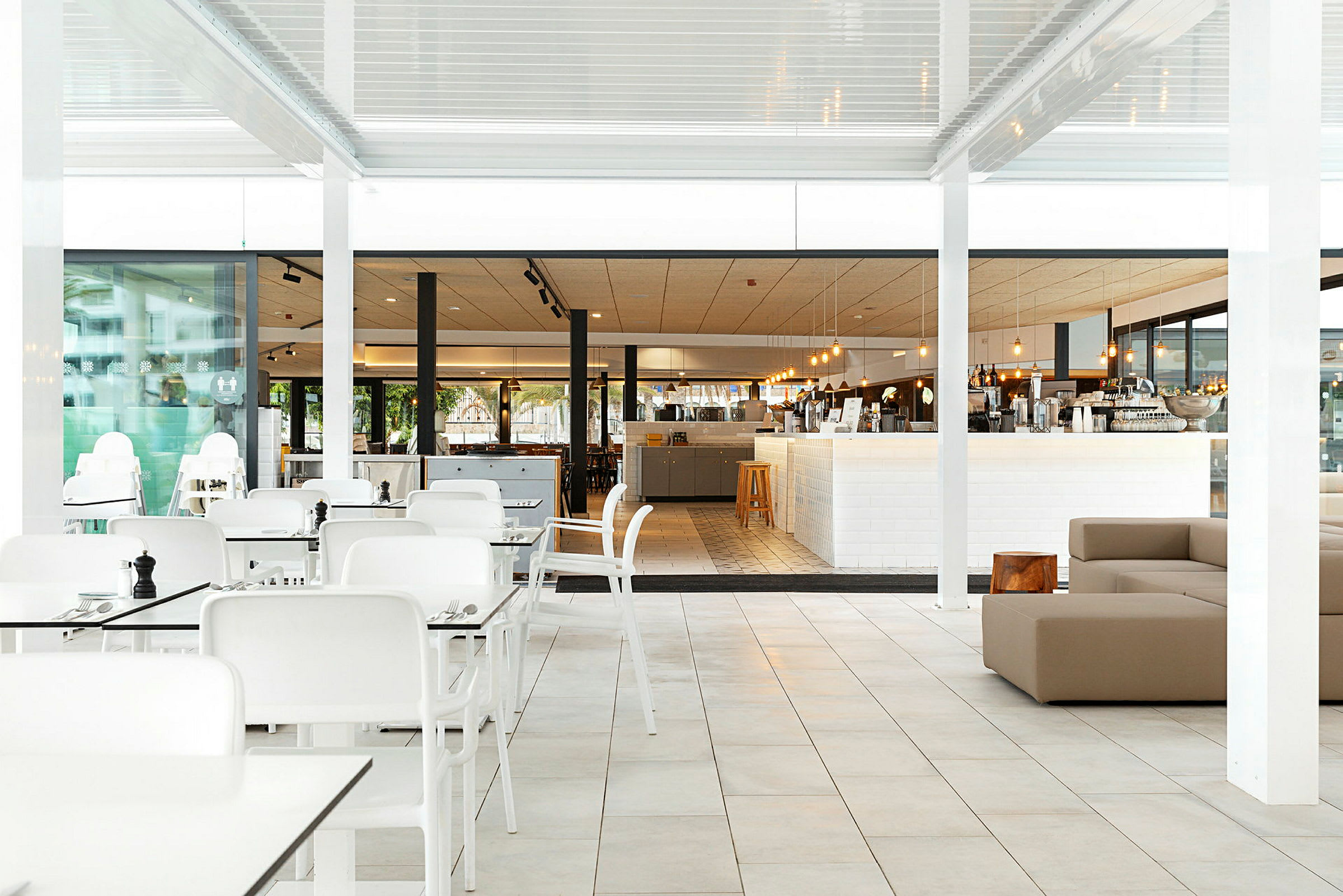 Bilde av en restaurant med hvite bord og stoler samt en lys spisesal. (AI-generert tekst)