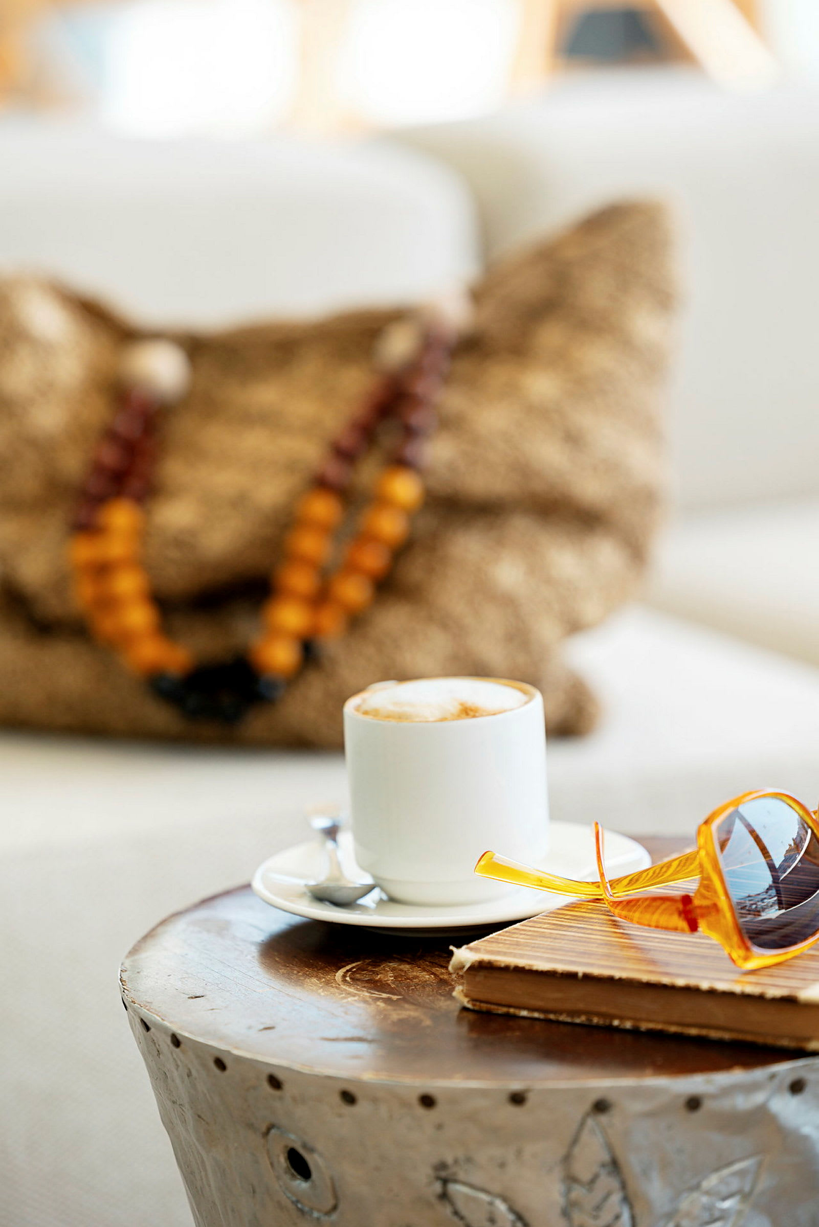 En kopp kaffe på et bord sammen med briller og en notisbok. (AI-generert tekst)