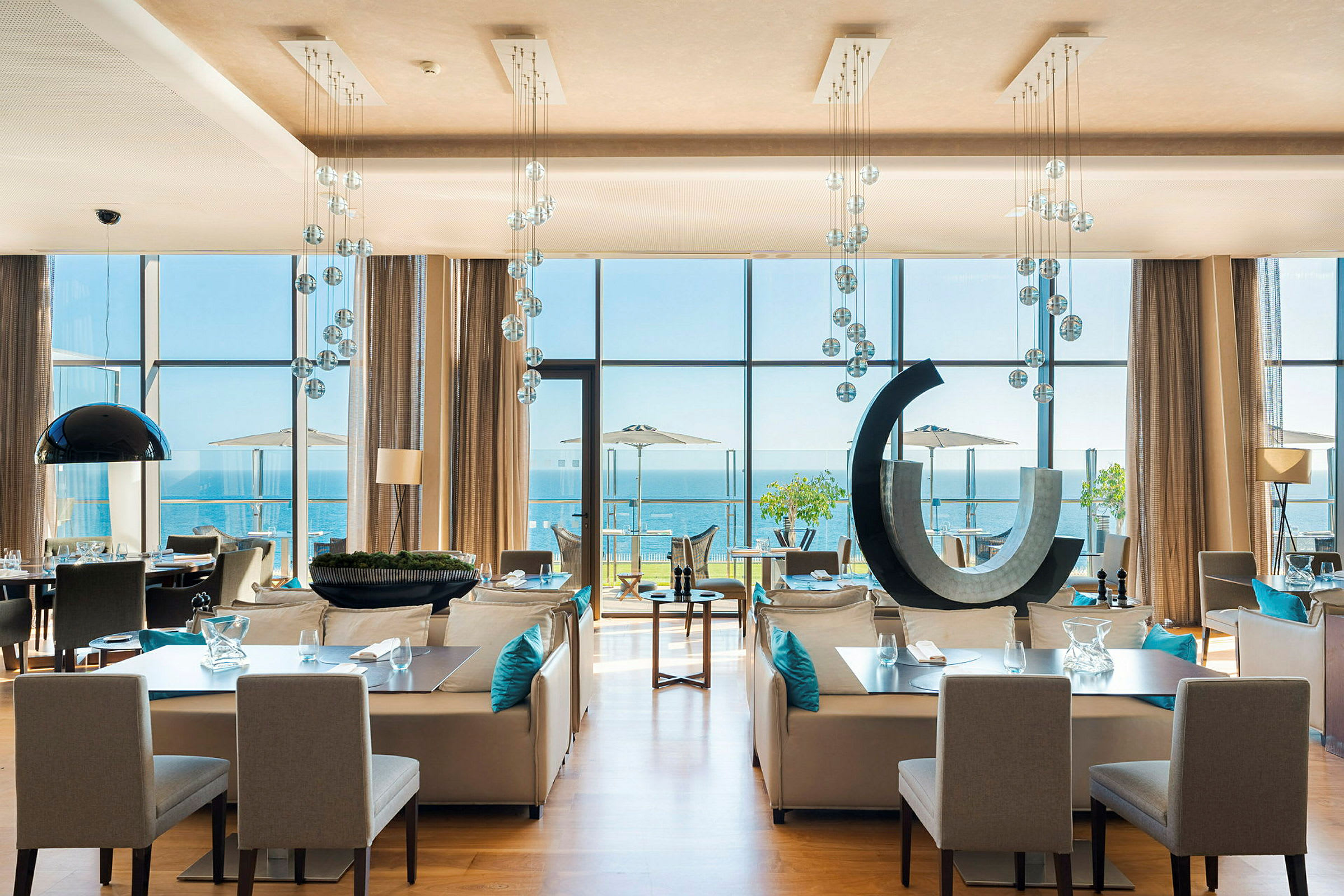 Moderne restaurant med store vinduer mot havet. (AI-generert tekst)