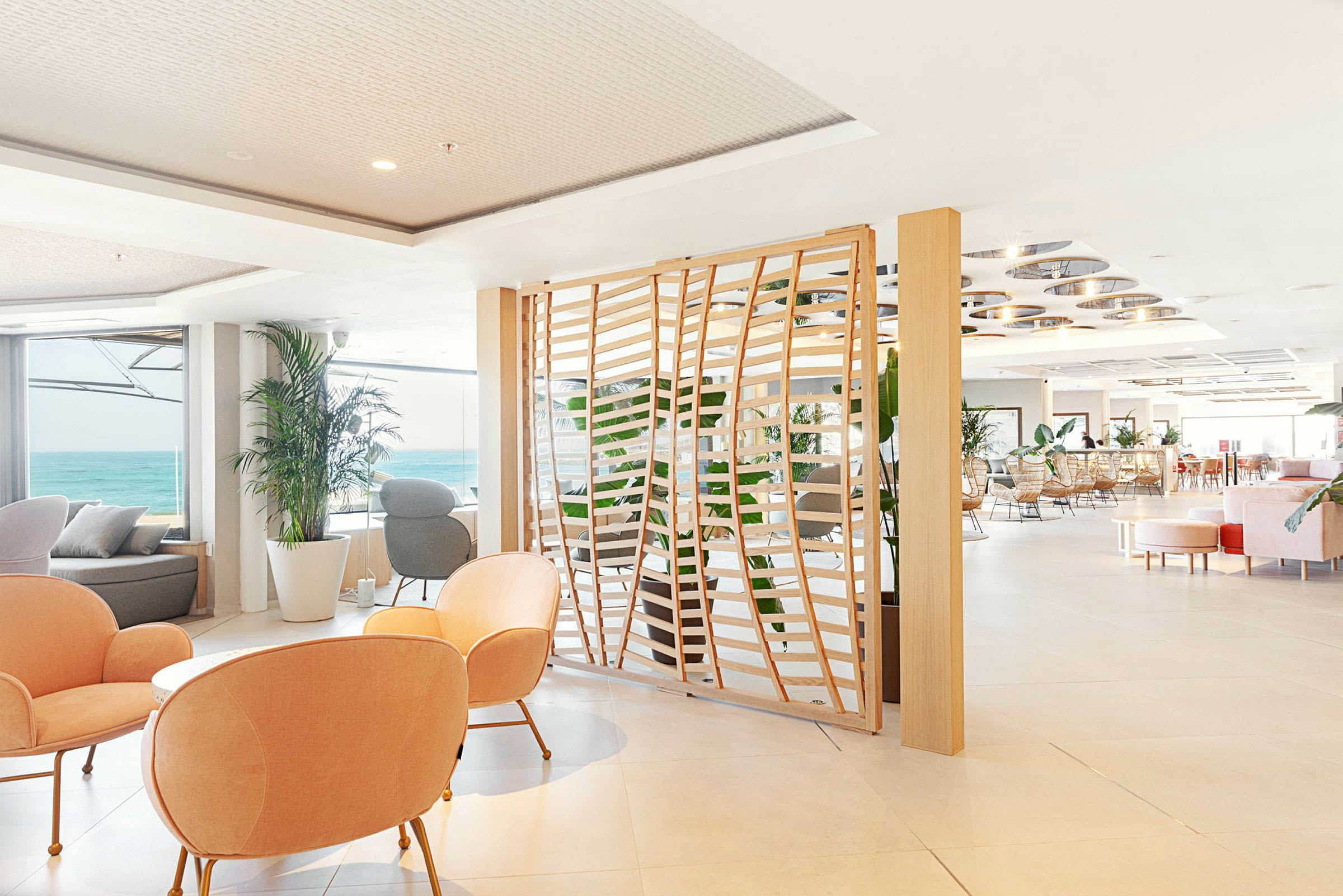 Lyst innredet hotellounge med utsikt over havet. (AI-generert tekst)