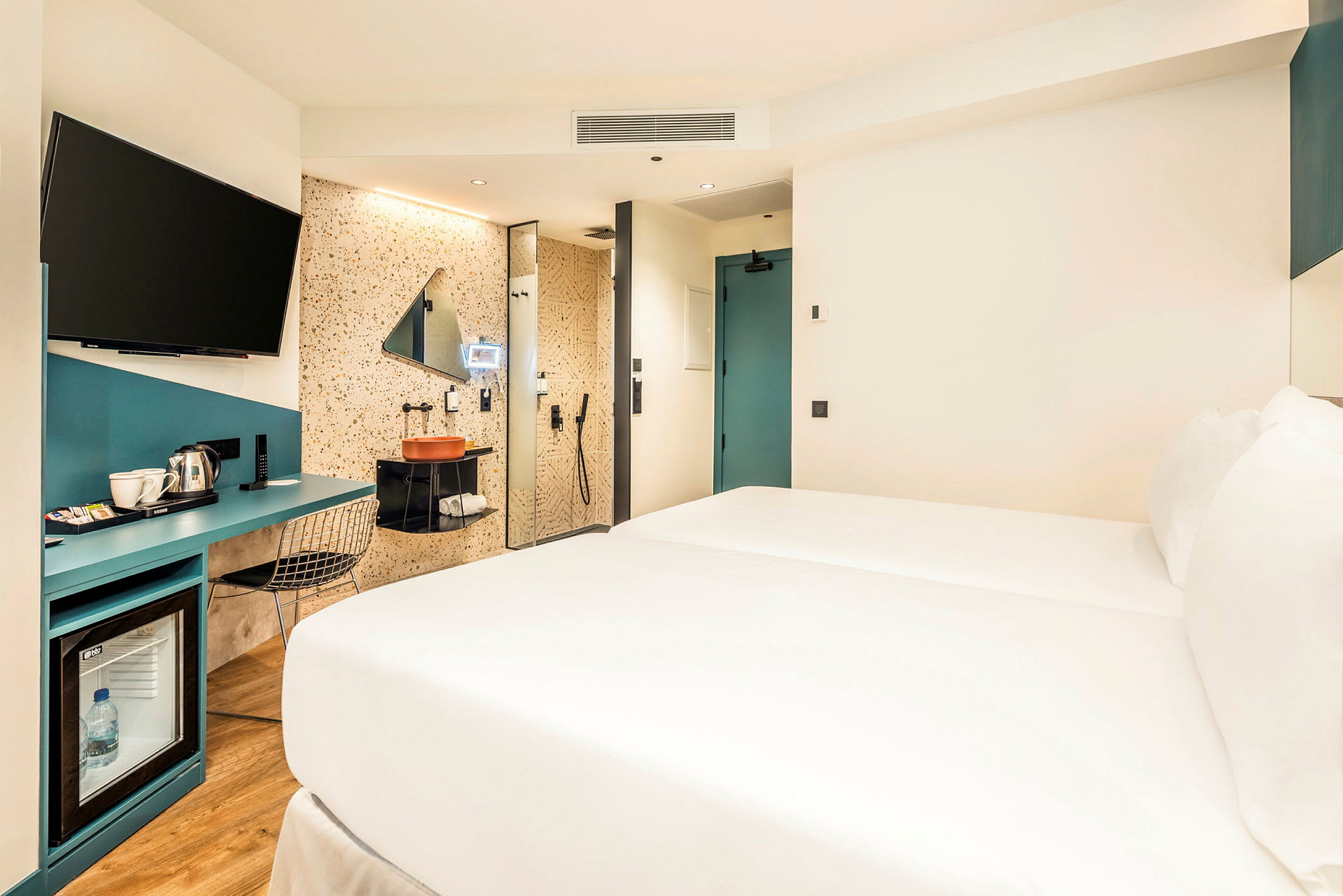 Hotellrom med seng, skrivebord og badeområde. (AI-generert tekst)