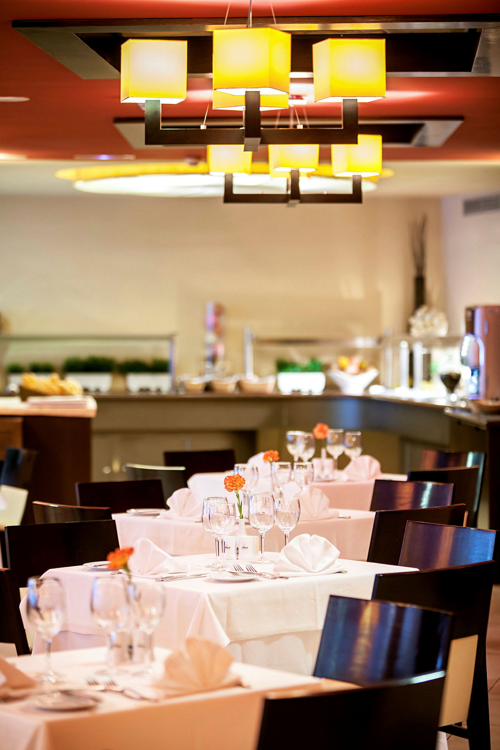 Restaurant med dekkede bord, stoler og lys innredning. (AI-generert tekst)