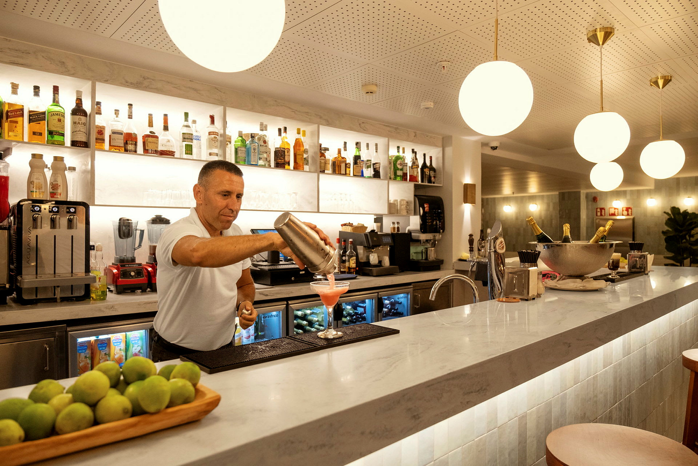 Barområde med en kokk som heller opp en cocktail. (AI-generert tekst)