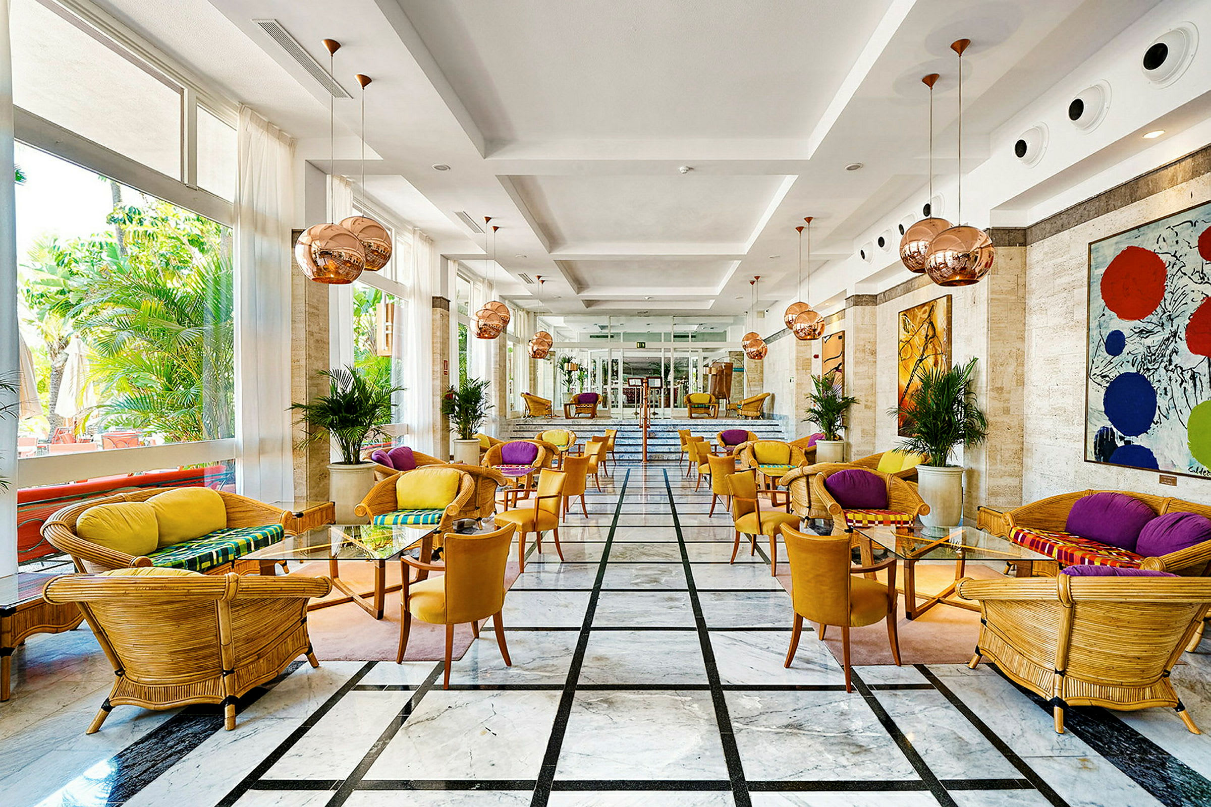 Interiør av en hotellbarlounge med fargerik innredning og store vinduer. (AI-generert tekst)