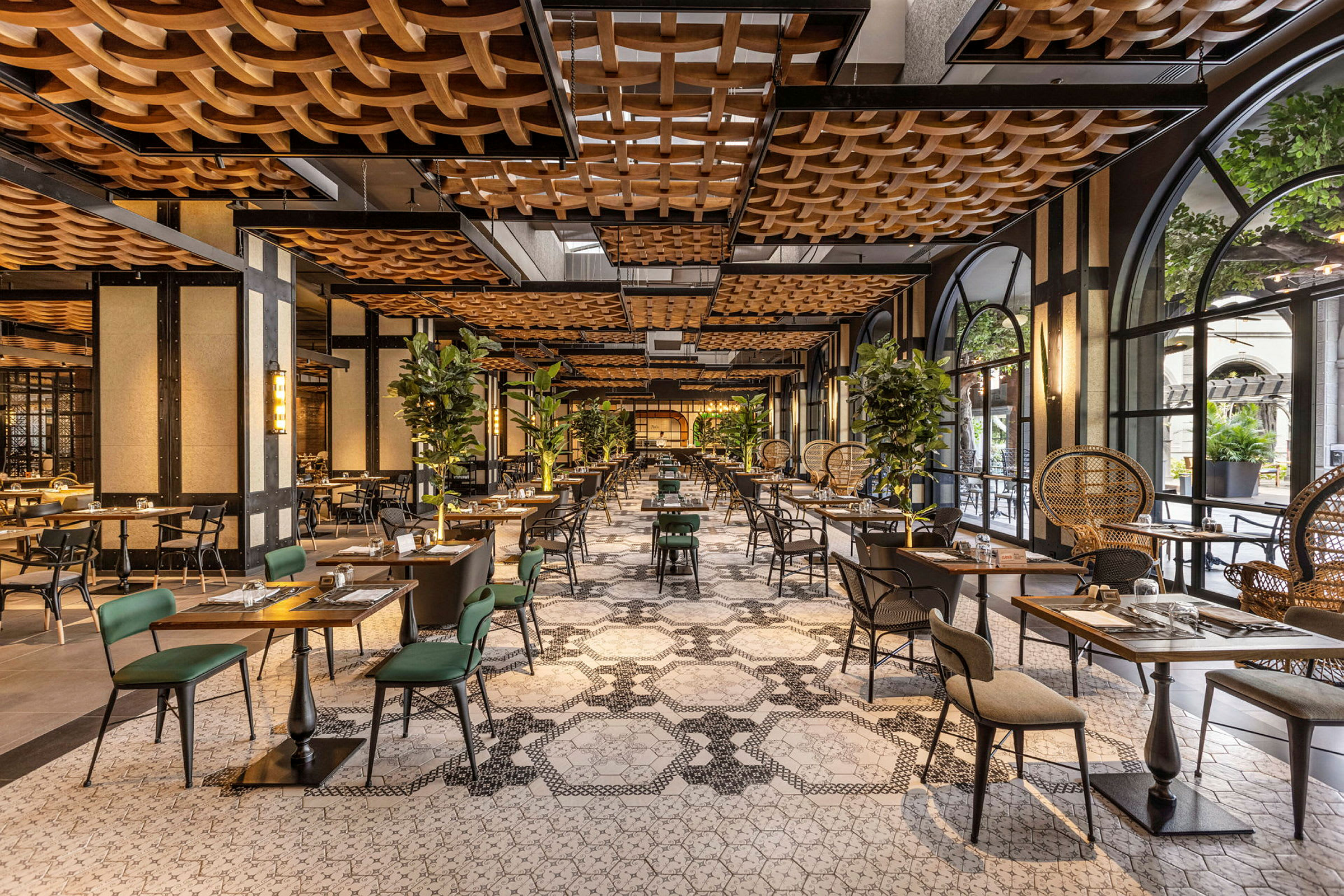 En innbydende restaurant med elegant innredning, bord og stoler, samt grønne planter som dekor. (AI-generert tekst)